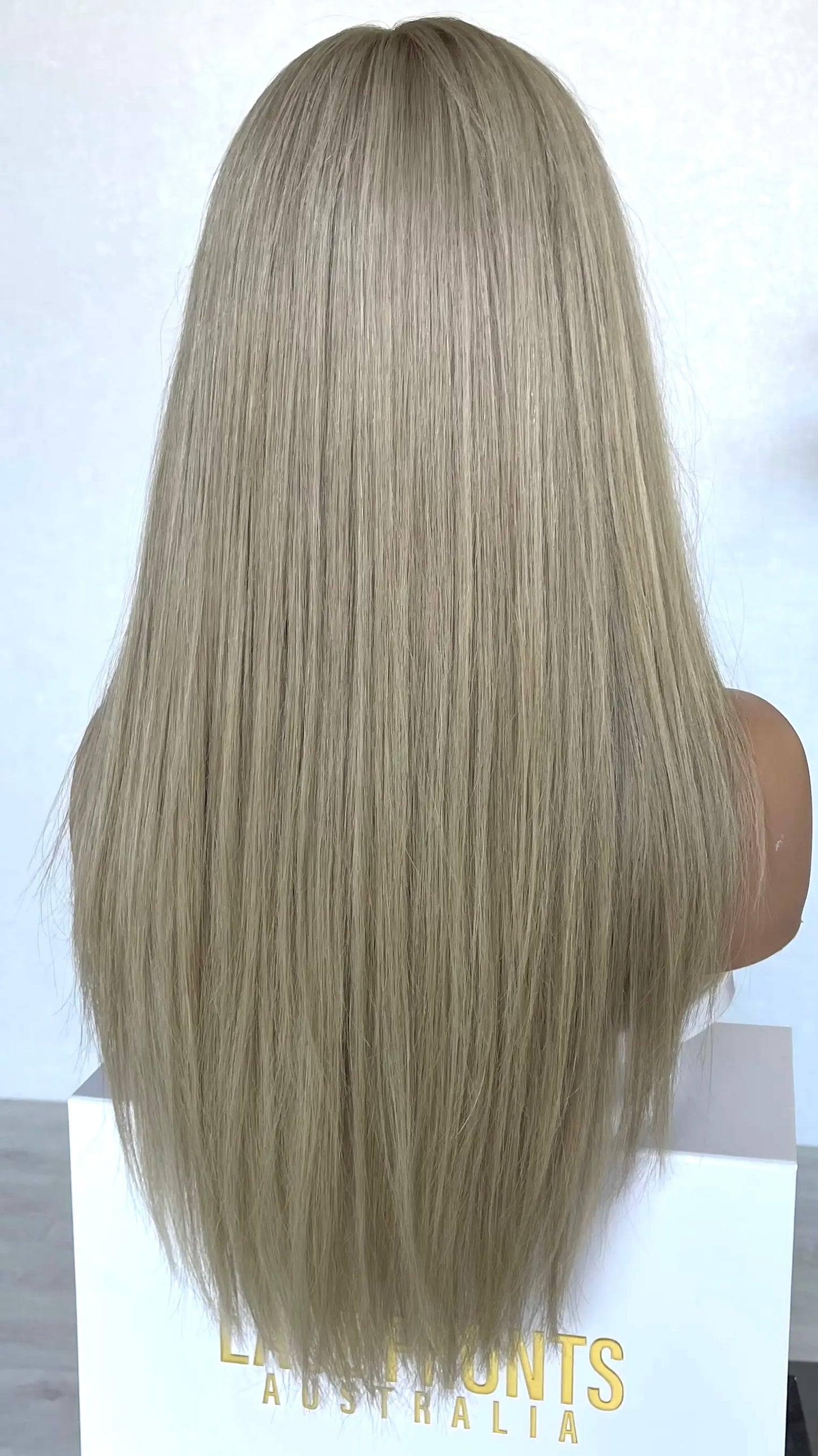 Back view of the CHARLI wig, showcasing its cool-toned pearly ash blonde shade with a sleek, flowing look