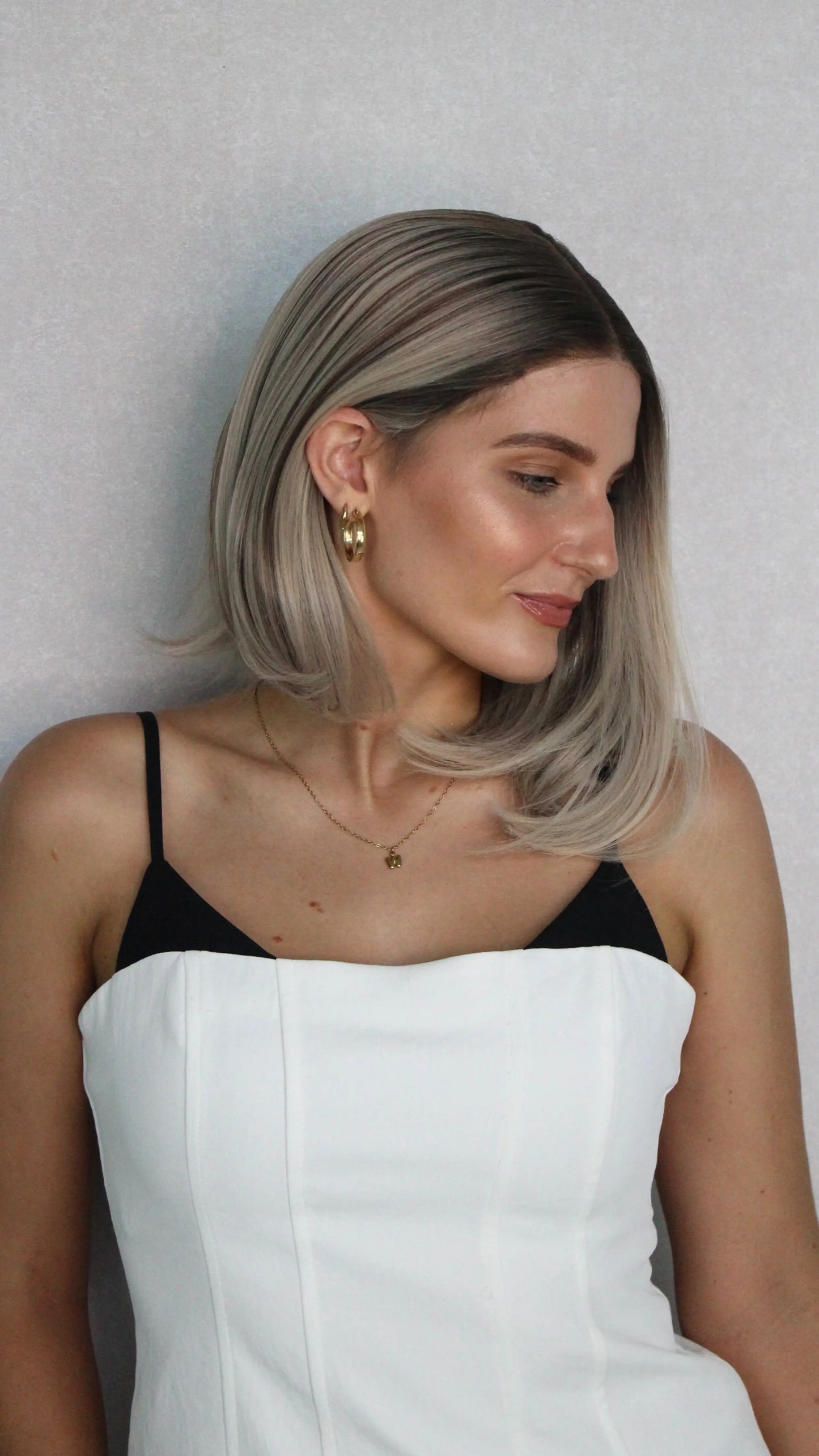 synthetic wig, darker root lacefront t-part synthetic. tucked behind ear, natural wig.
