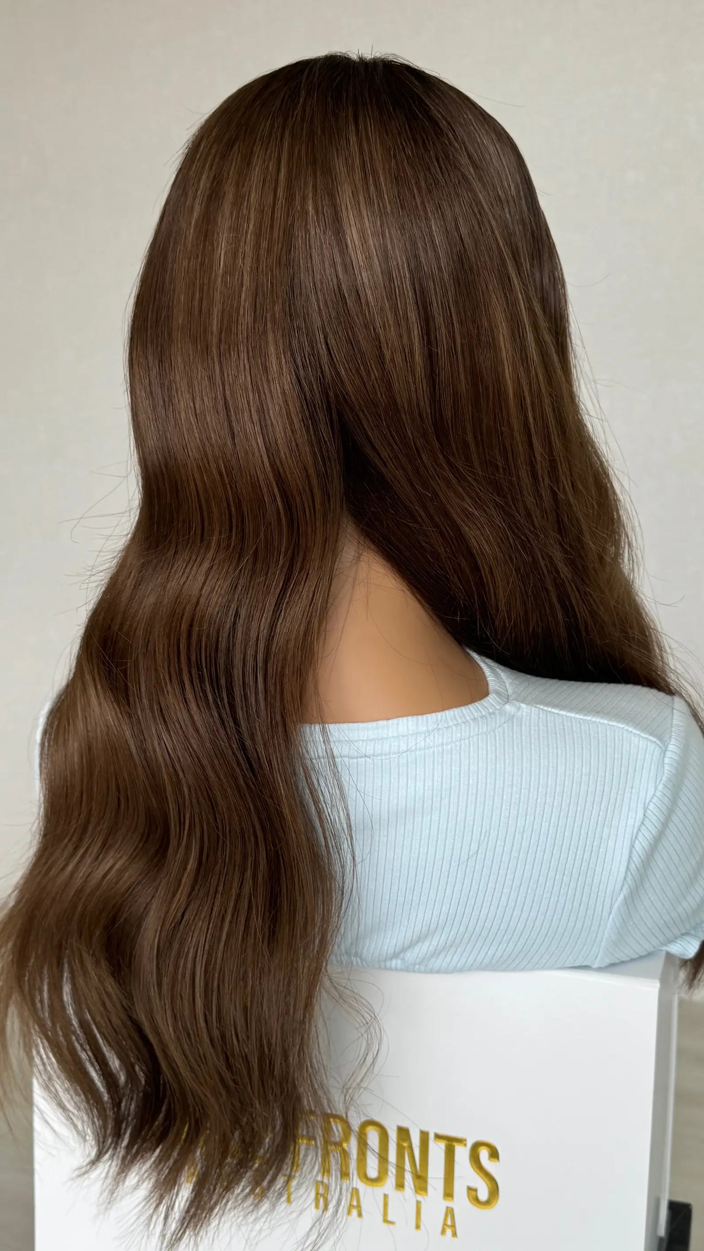 the Lexi wig styled in soft waves, enhancing the depth and richness of its chocolate brunette colour for a voluminous, elegant look