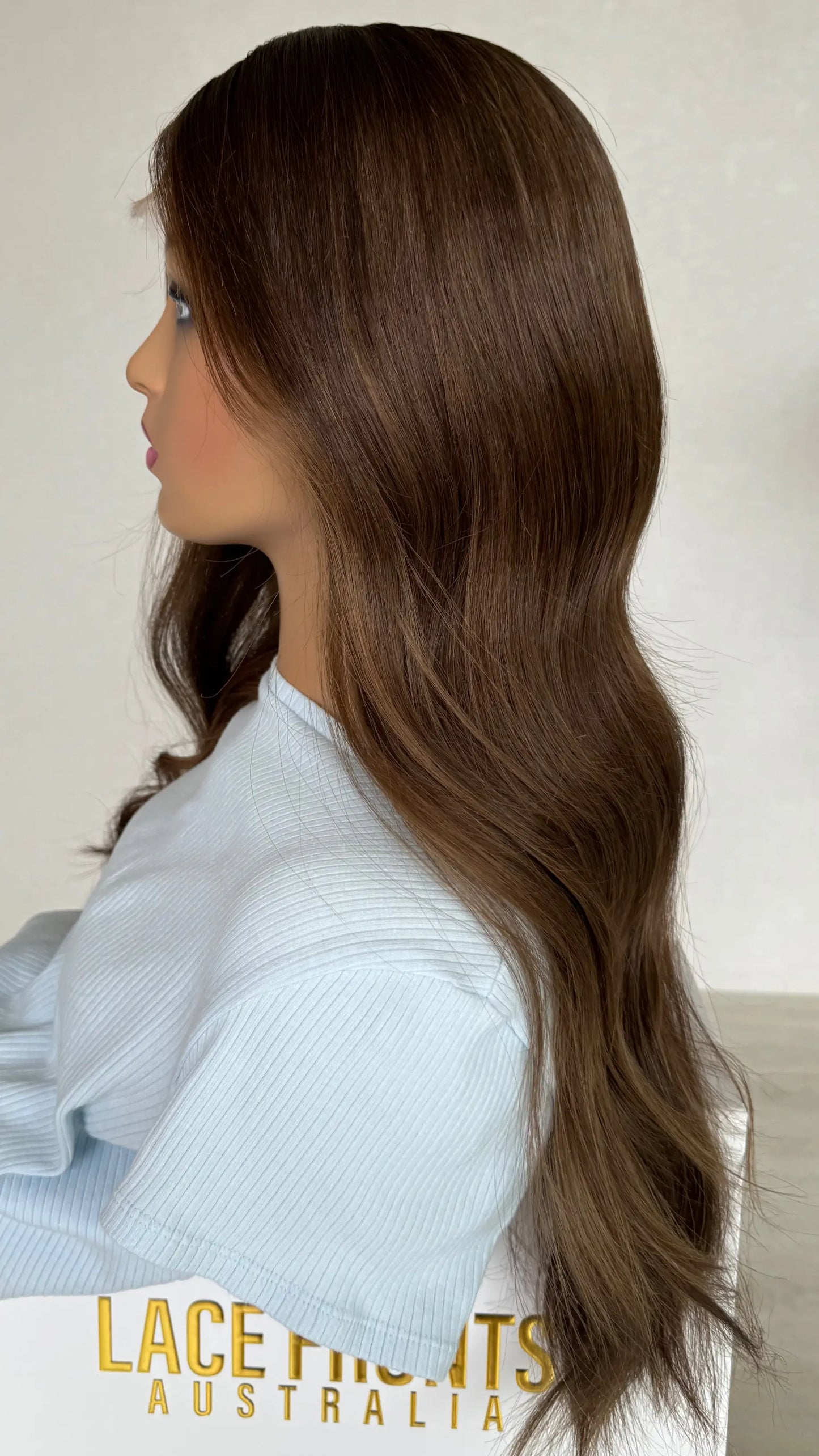 side profile of the Lexi wig, highlighting its silky texture and warm brunette tones with a soft, natural finish