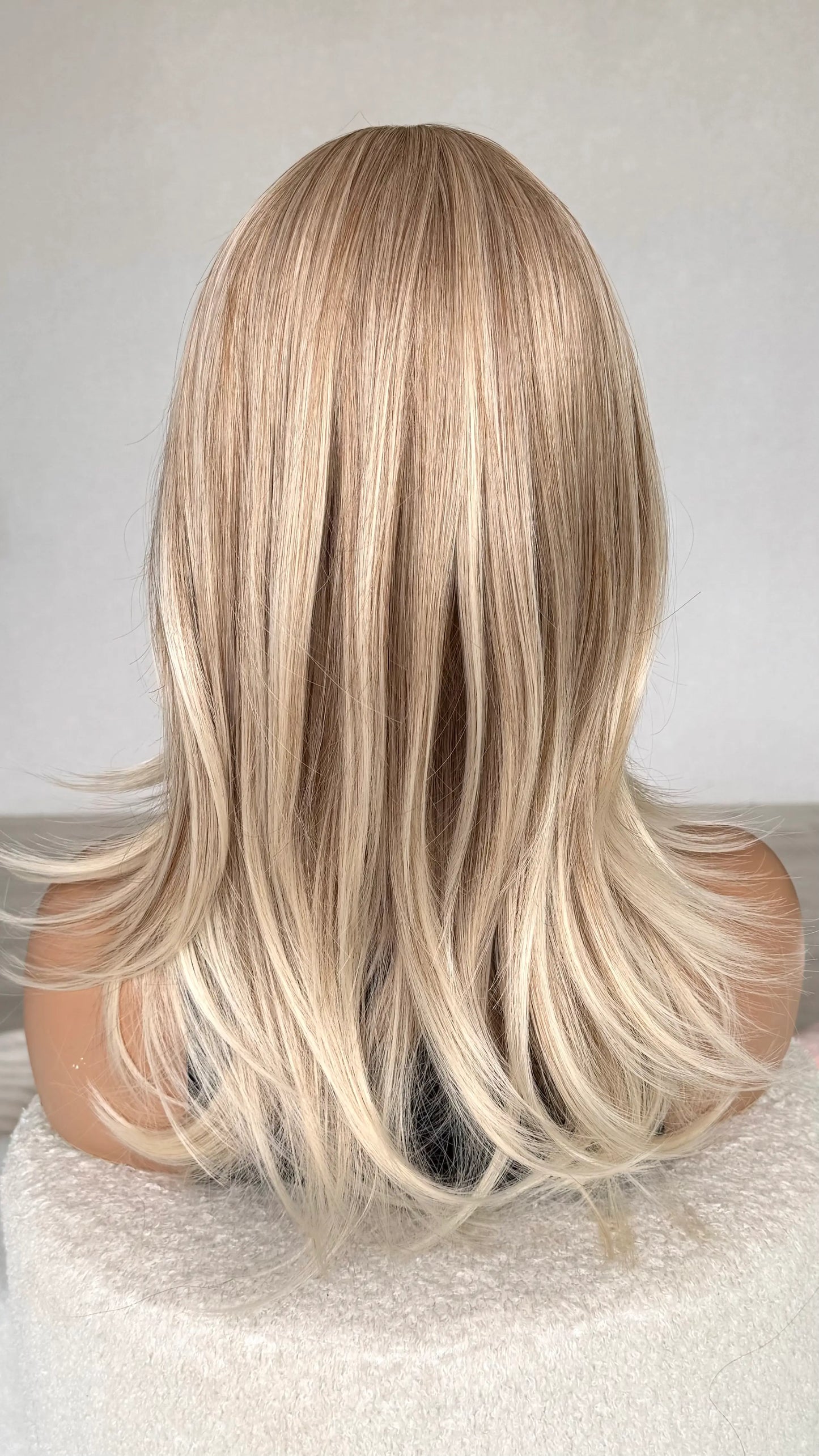 back view of blonde hair, sandy blonde to light platinum ends.