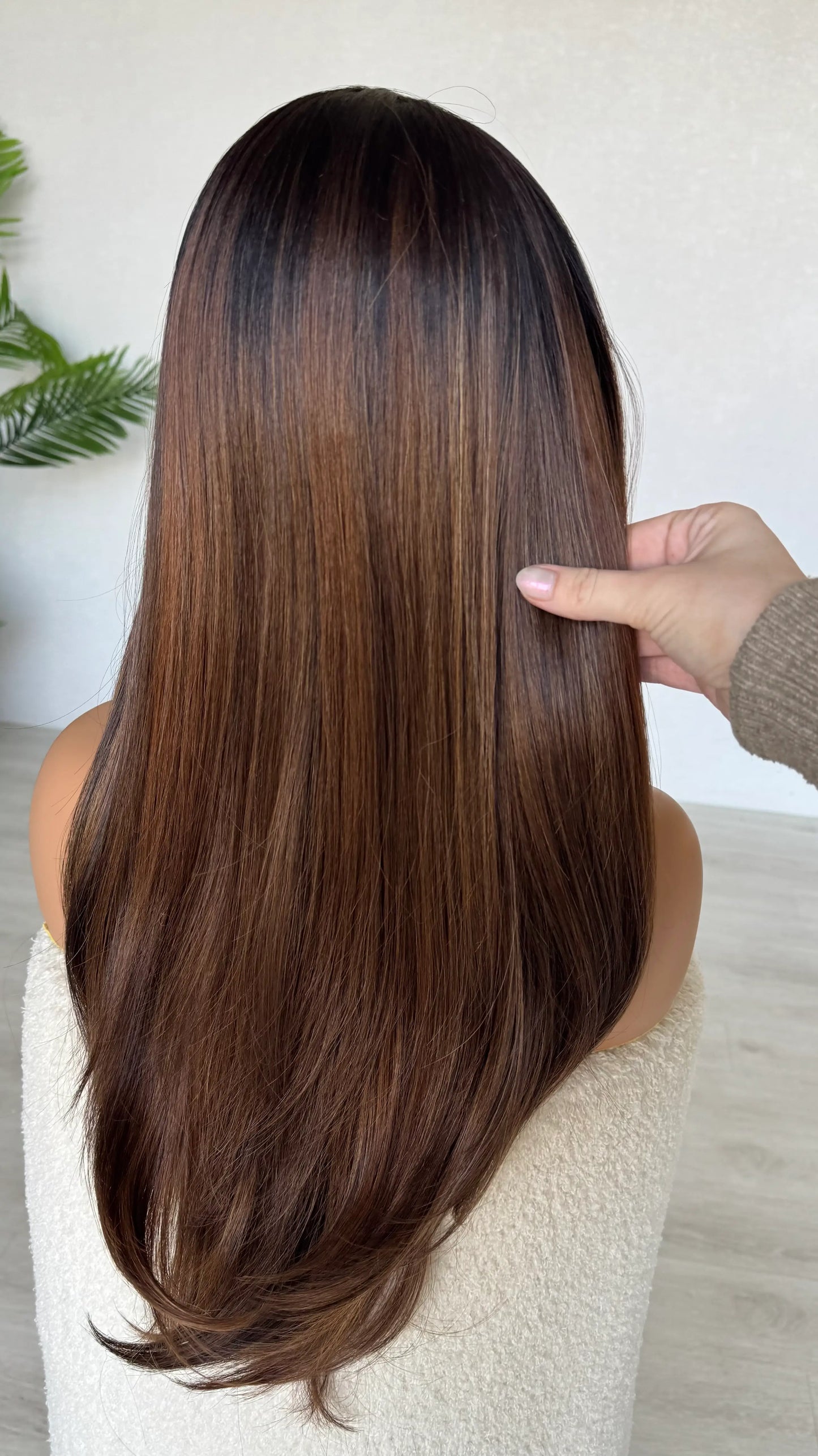 lacefront wig from behind, holding the long ombre brunette hair, light layers throughout, dark root, lighter ends.