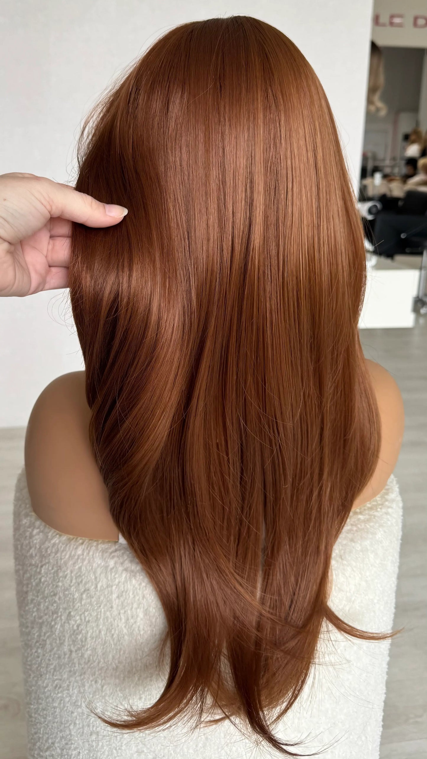 dallas from back view, holding long ginger wig