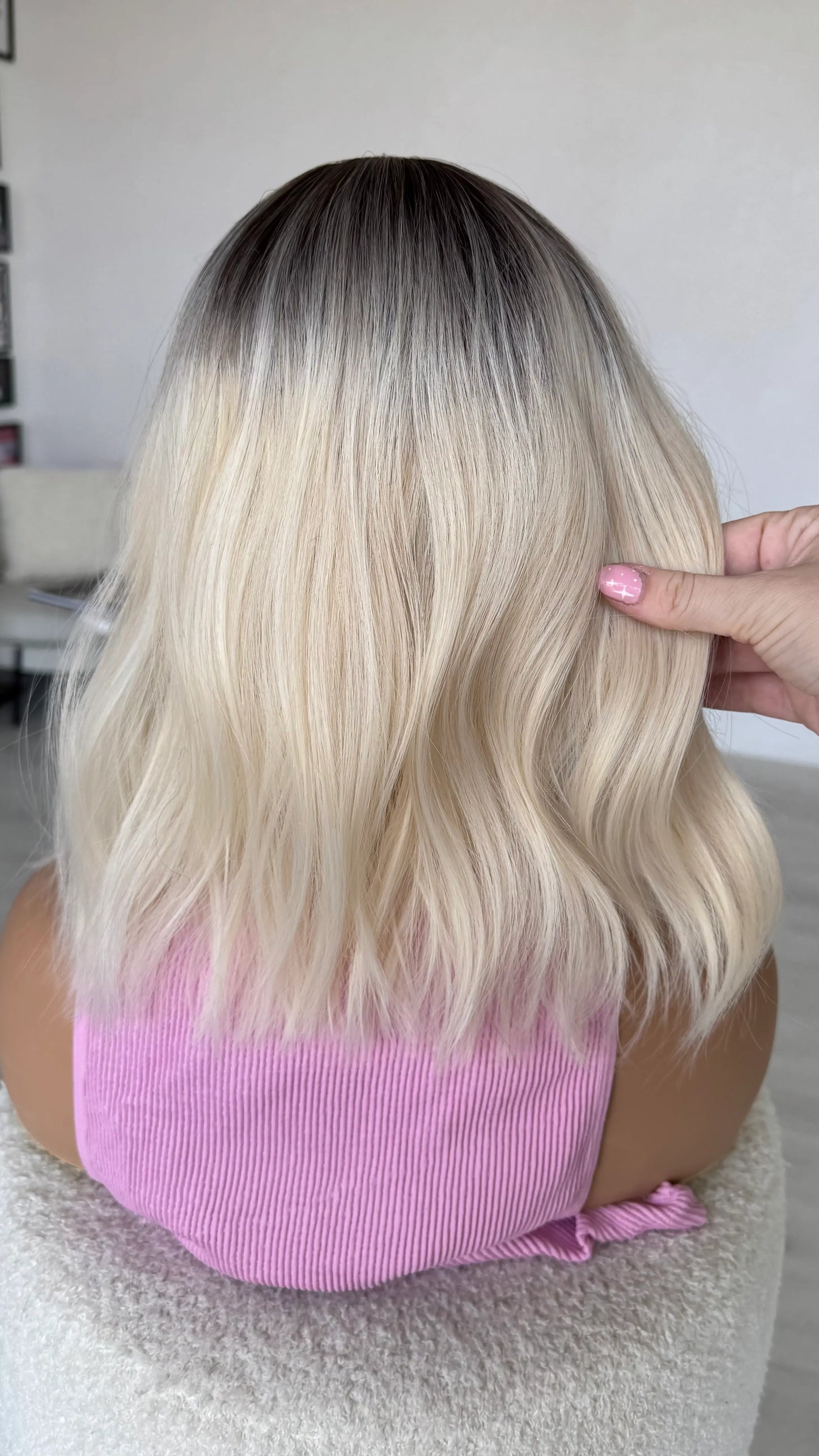 back view holding soft white platinum blonde hair.