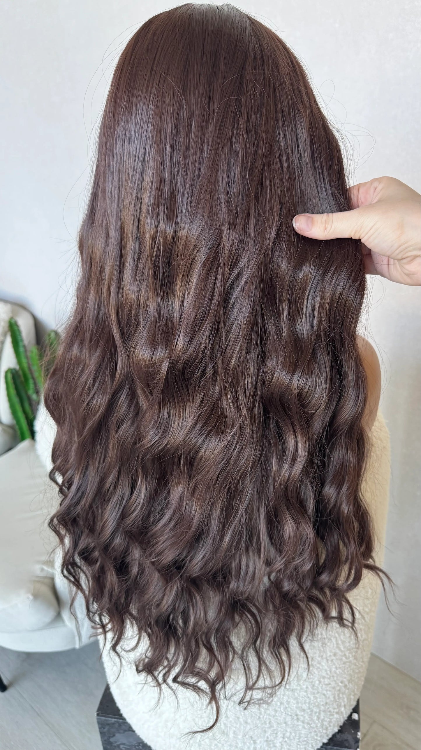 back view holding long wavy hair, heat safe wig australia, dark plum colour.