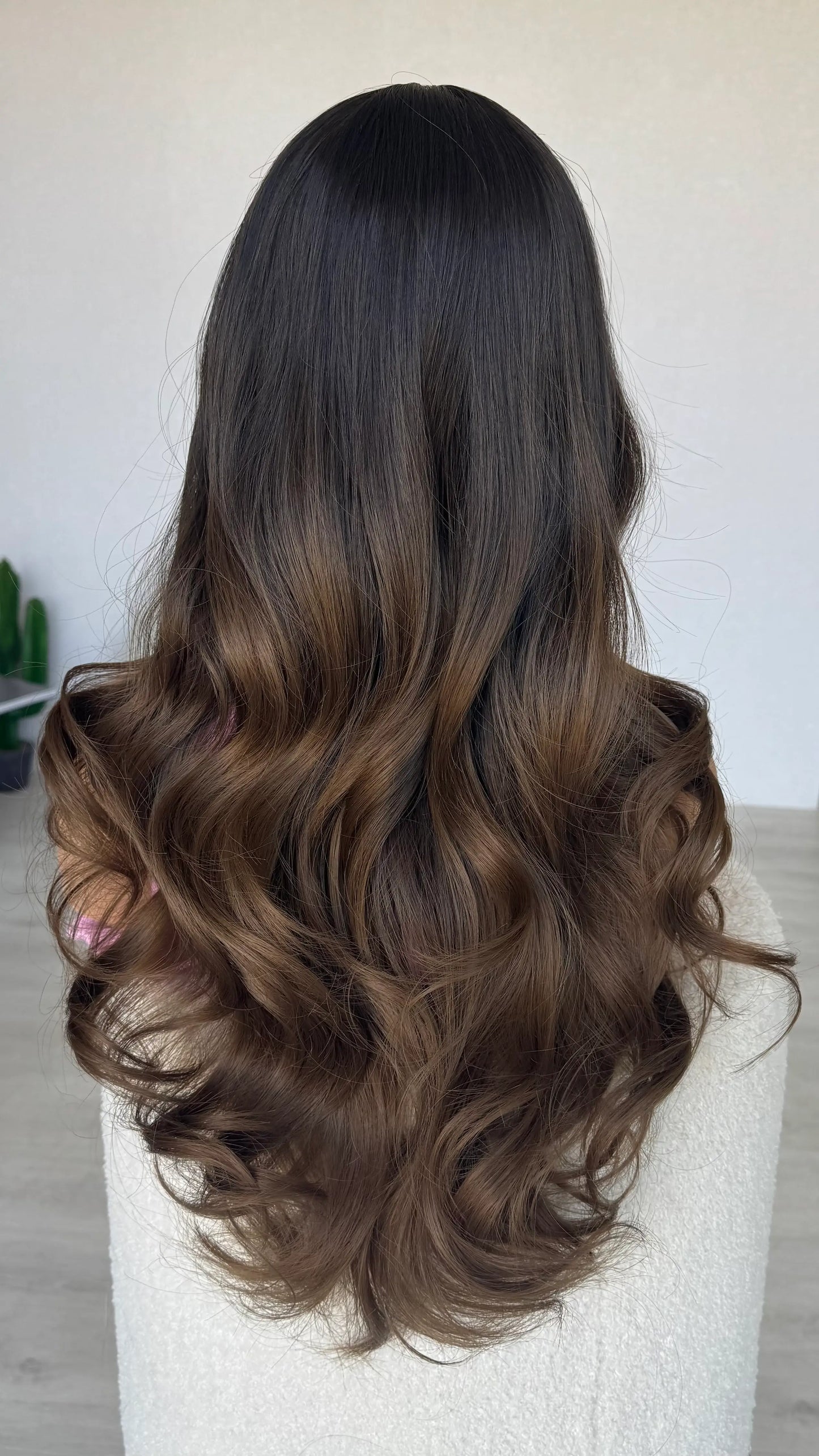 long brown hair middle part, darker root to brown ends.