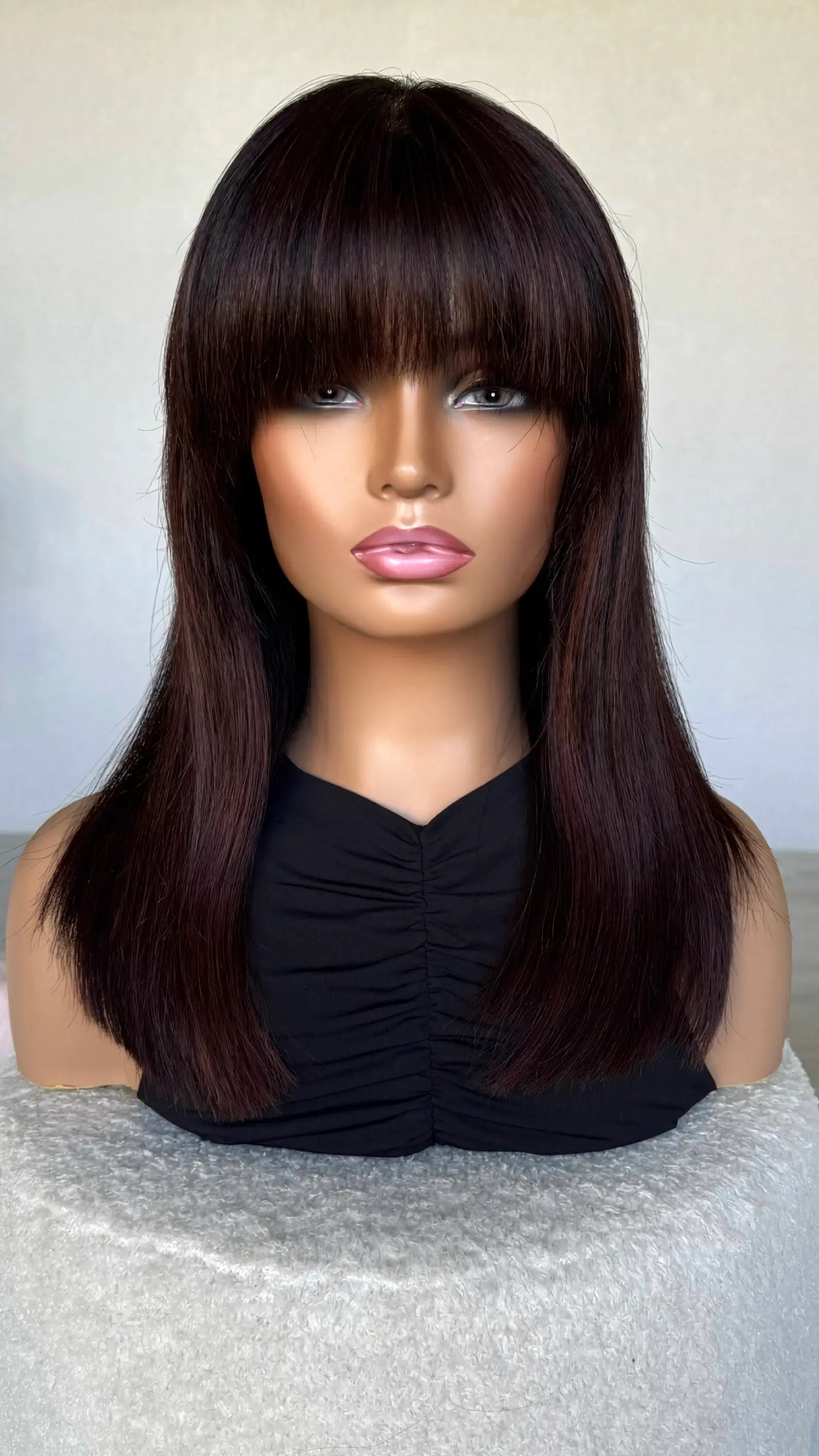 dark brown wig with burgundy red highlights. thick fringe cut to just below eyebrow.