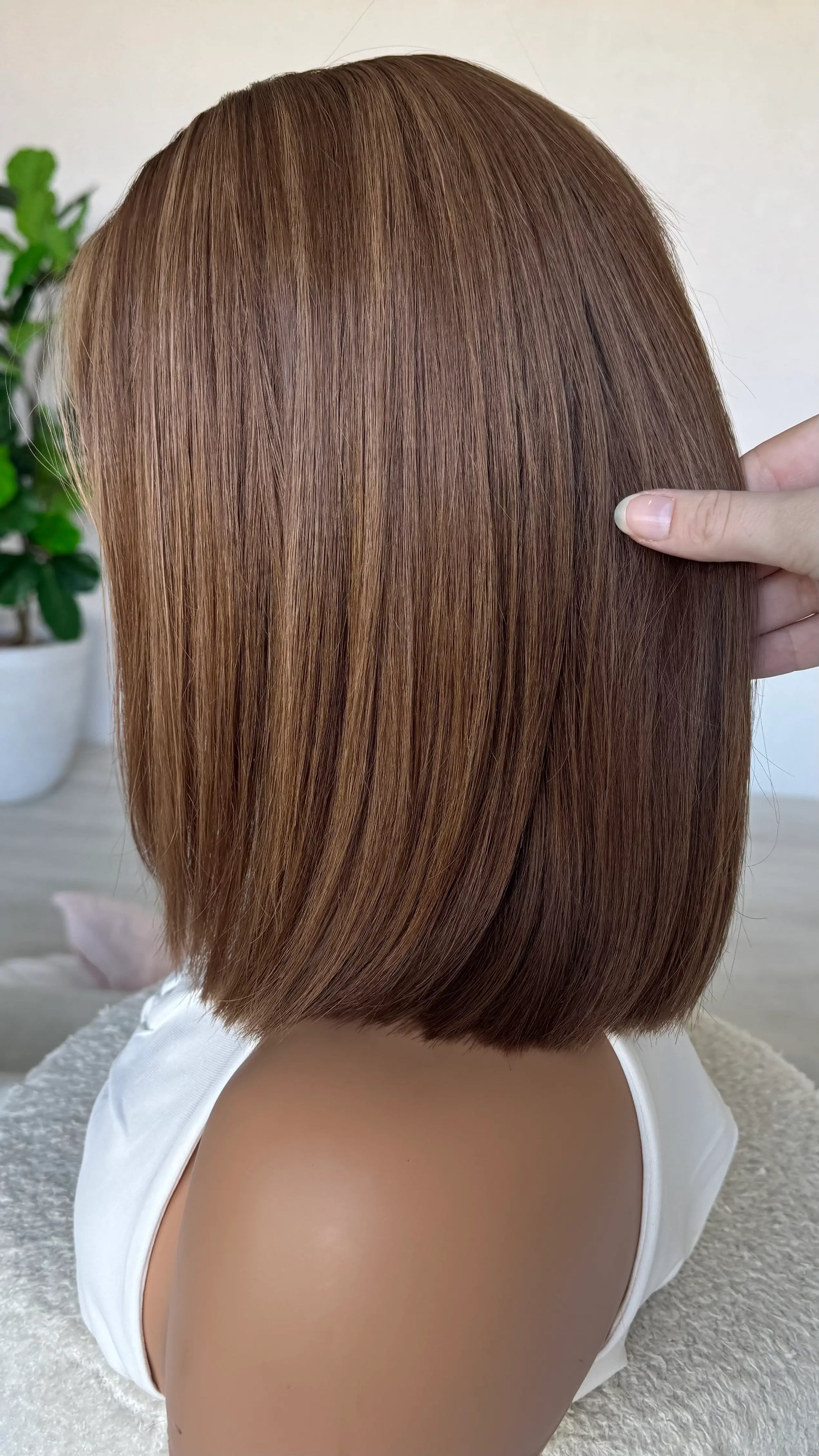lacefront human hair side on view, caramel brunette with highlights. 14 inch bob length hair.