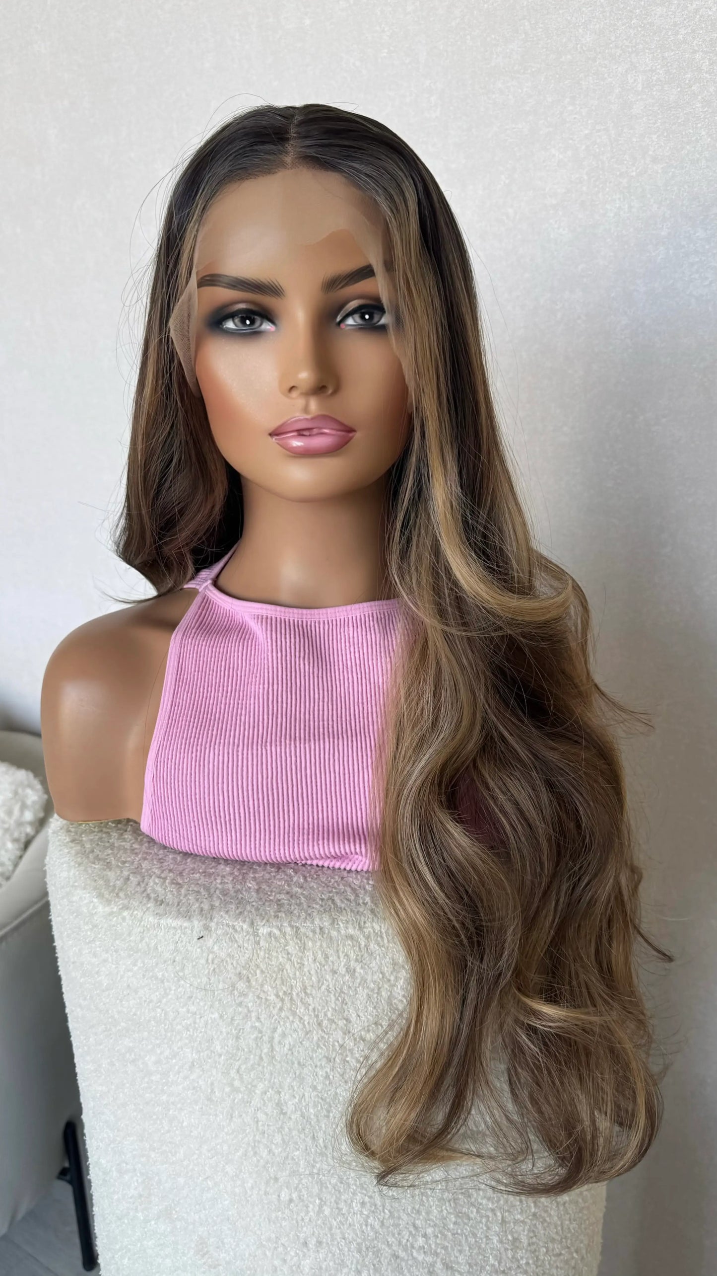 glueless synthetic wig, middle part, dark brunette with warm highlights.