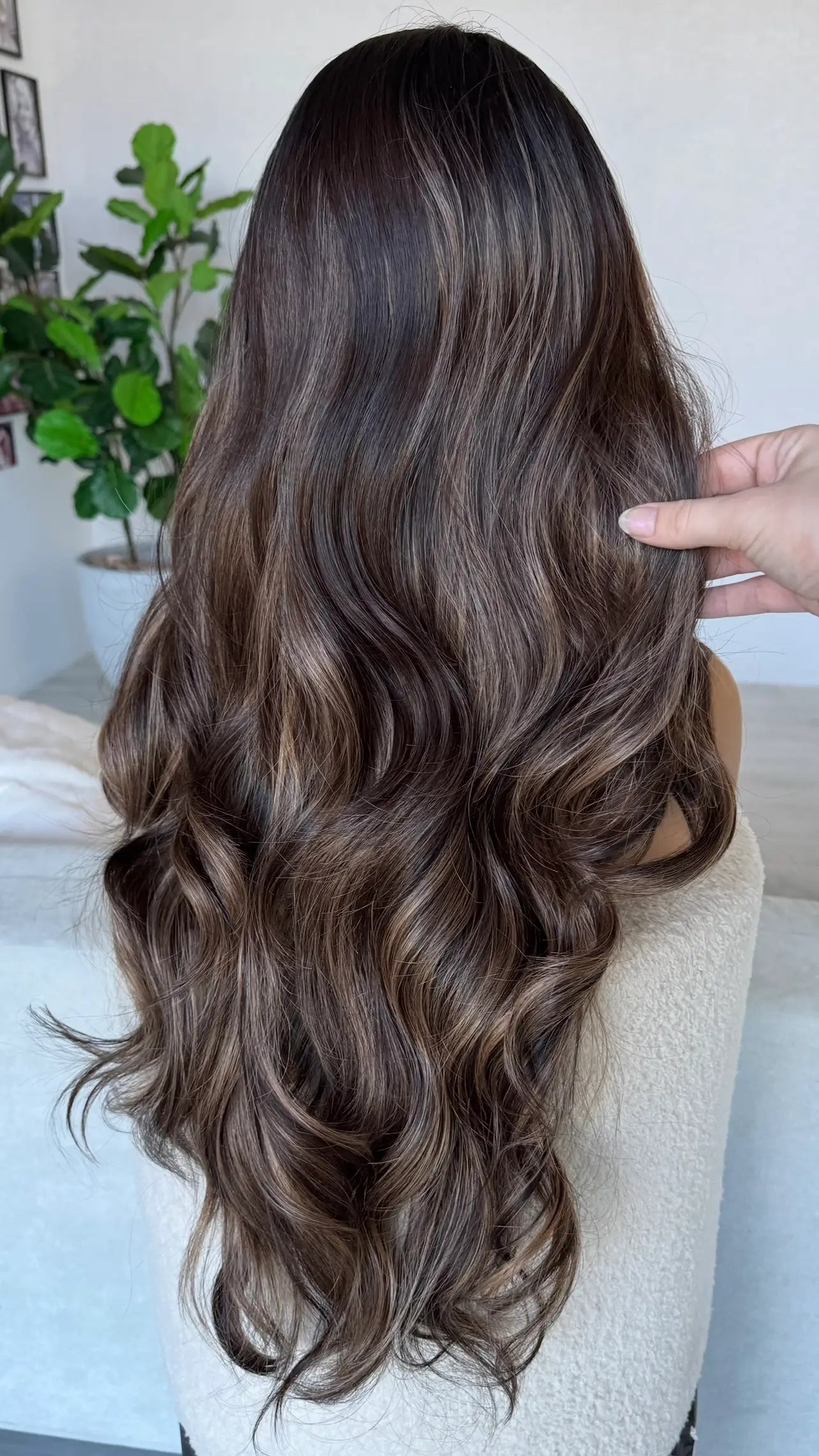 holding hair back view, long dark synthetic with highlights