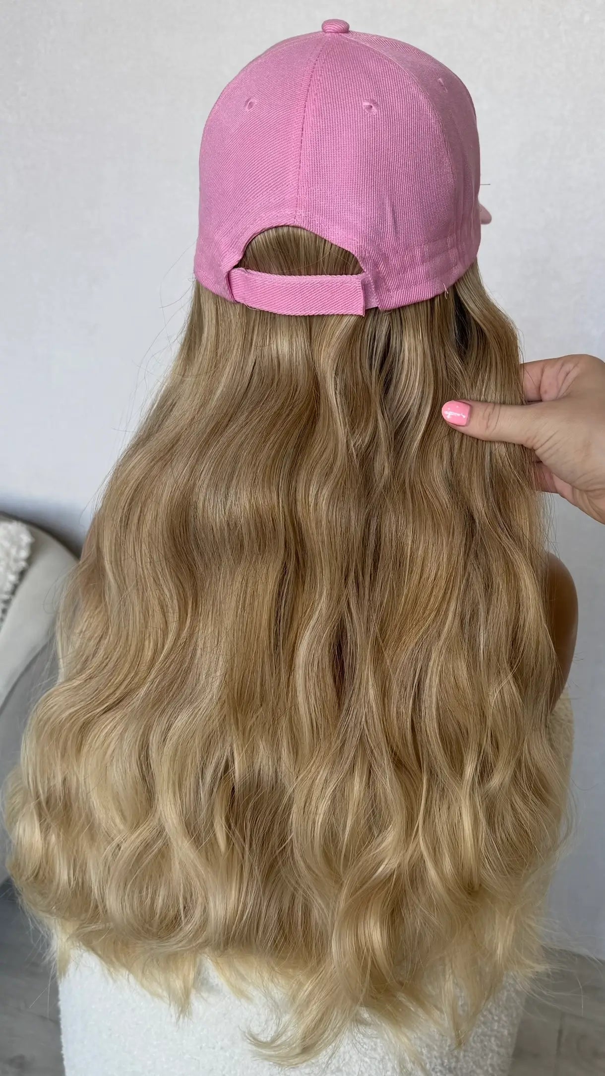 holding soft blonde hair from behind waves, heat safe wigs australia.