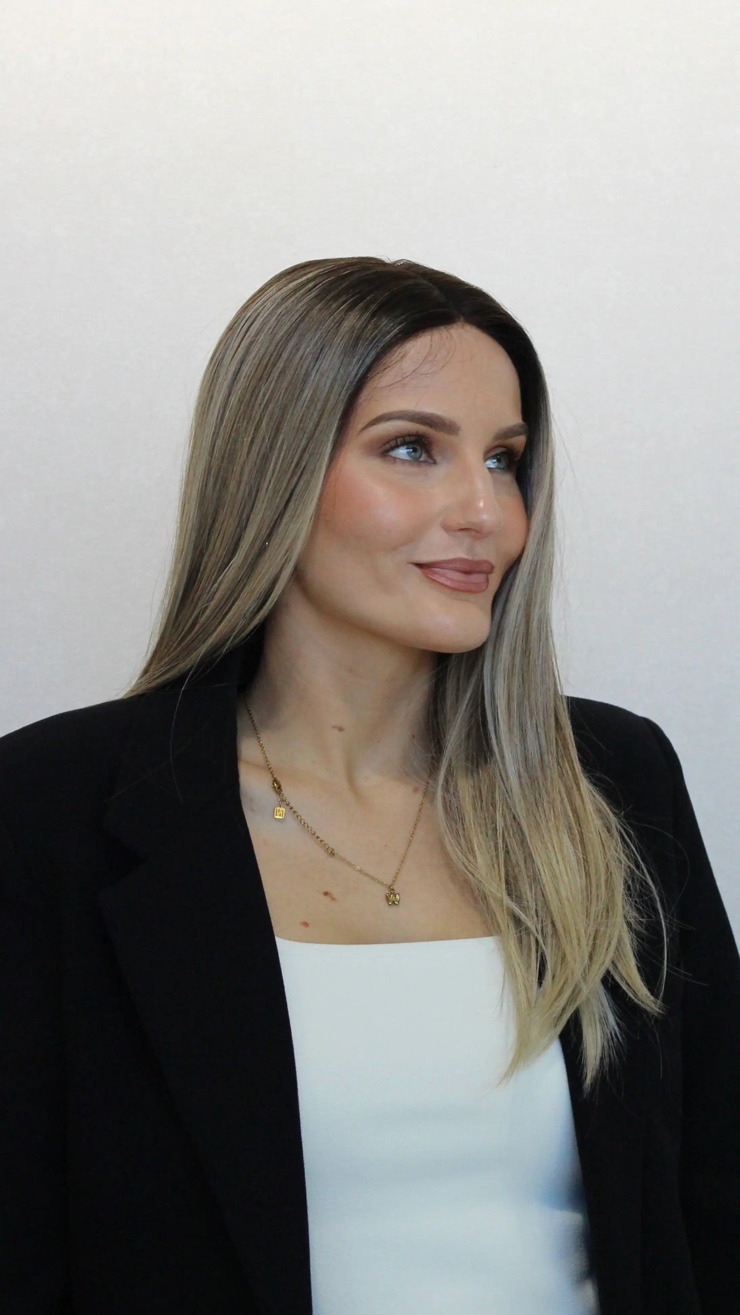 side on view, darker root to ombre blonde cool toned hair. heat safe synthetics.