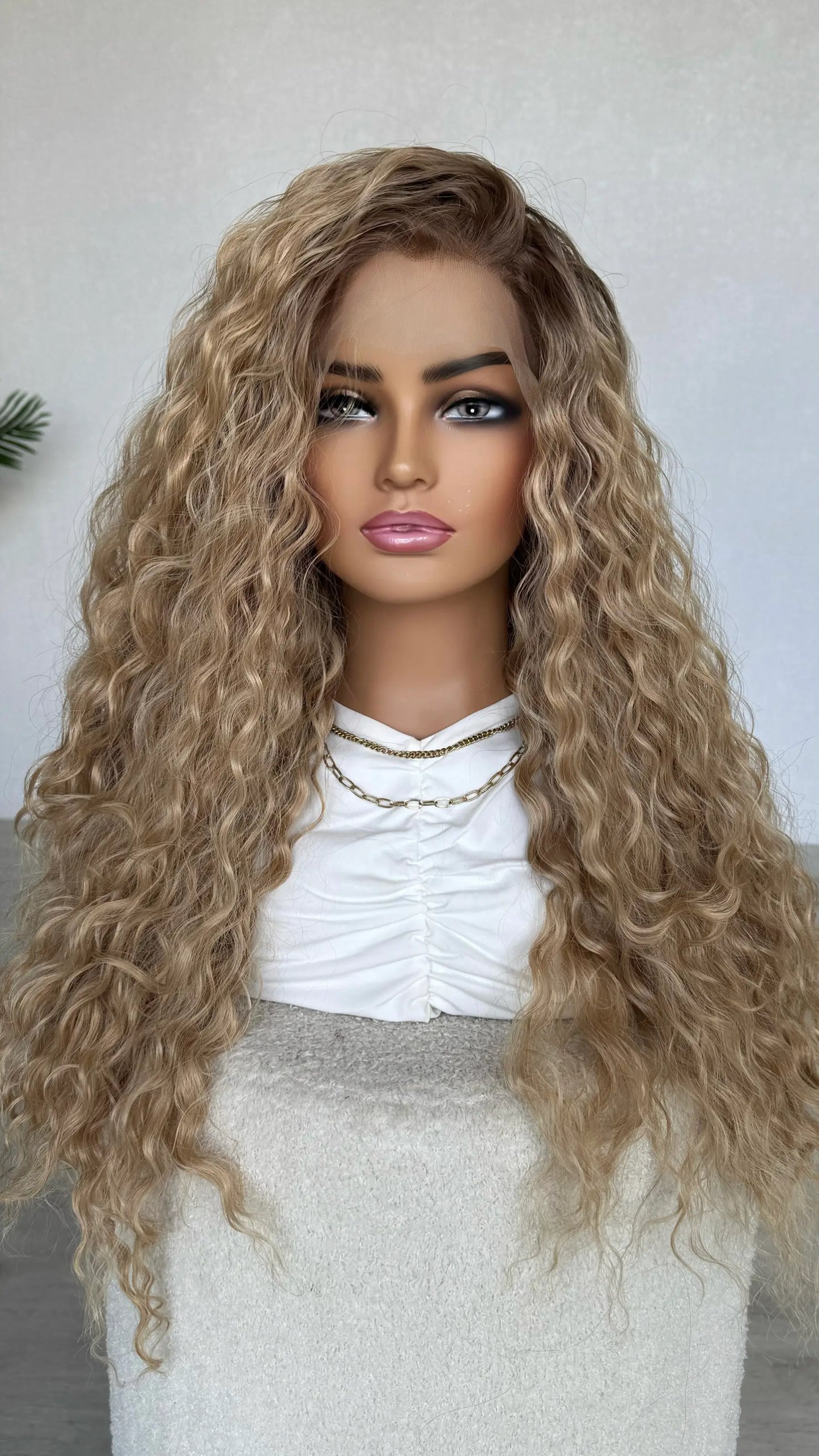 Mannequin head with long blonde curly wig on a plain background, lacefront wigs australia.