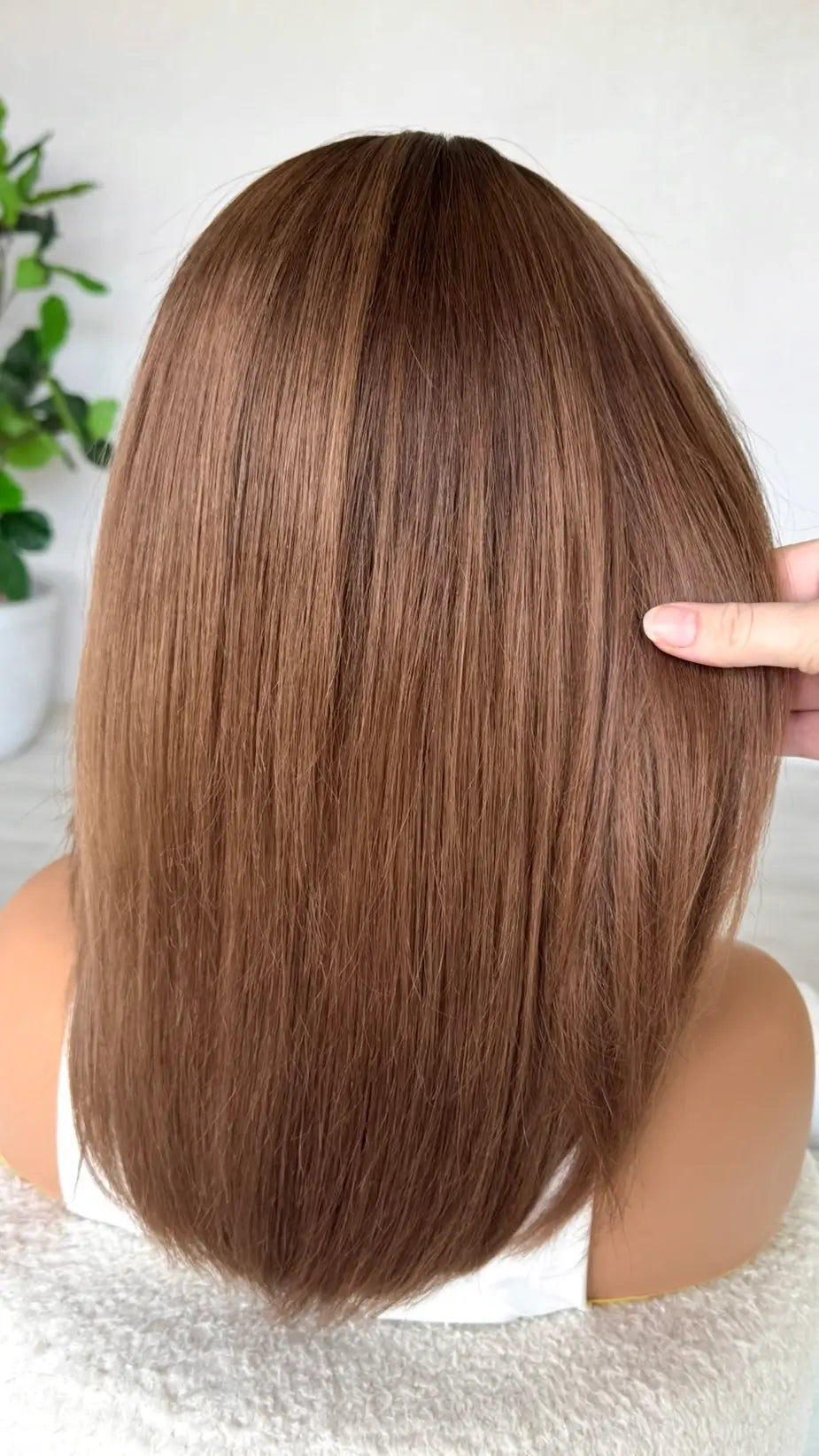 back view holding the brunette ombre hair, dark caramel brunette ends with middle part, 16 inches.