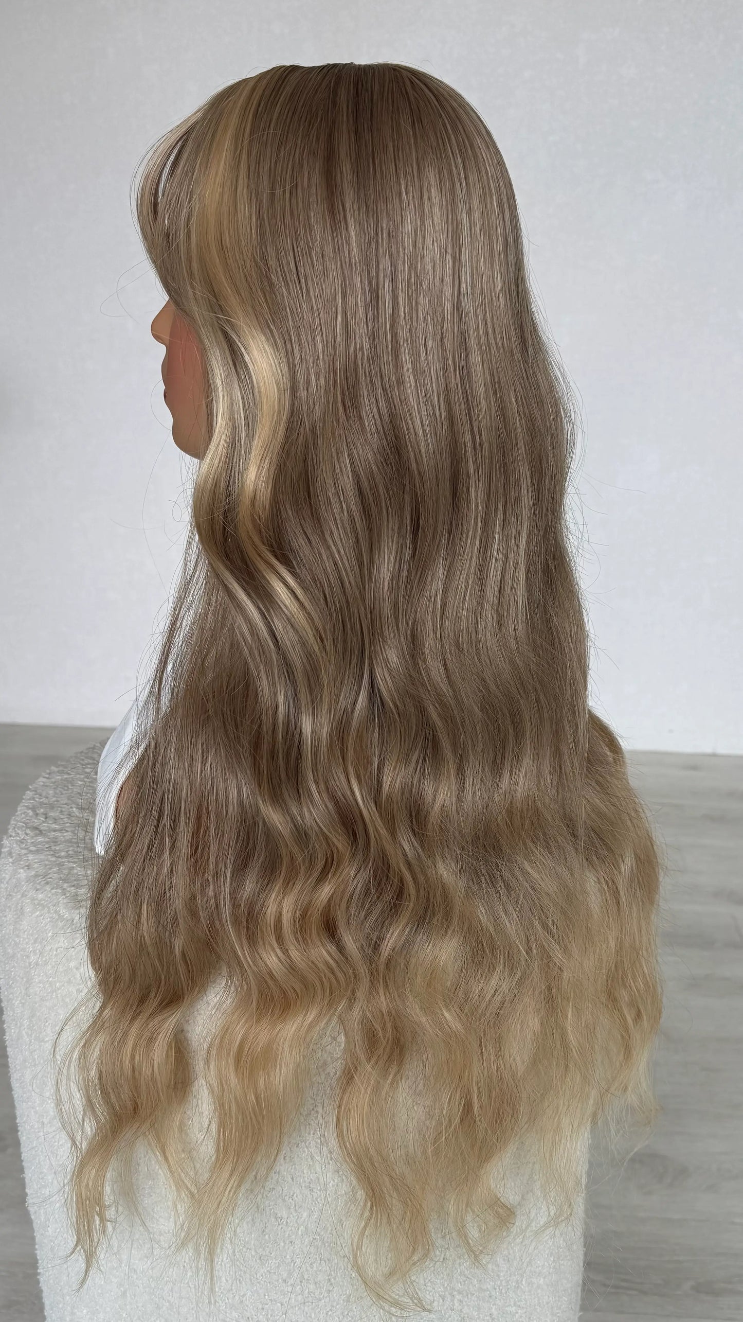siude view showing long blonde hair, slight wave with lighter ends, heat safe synthetic hair.
