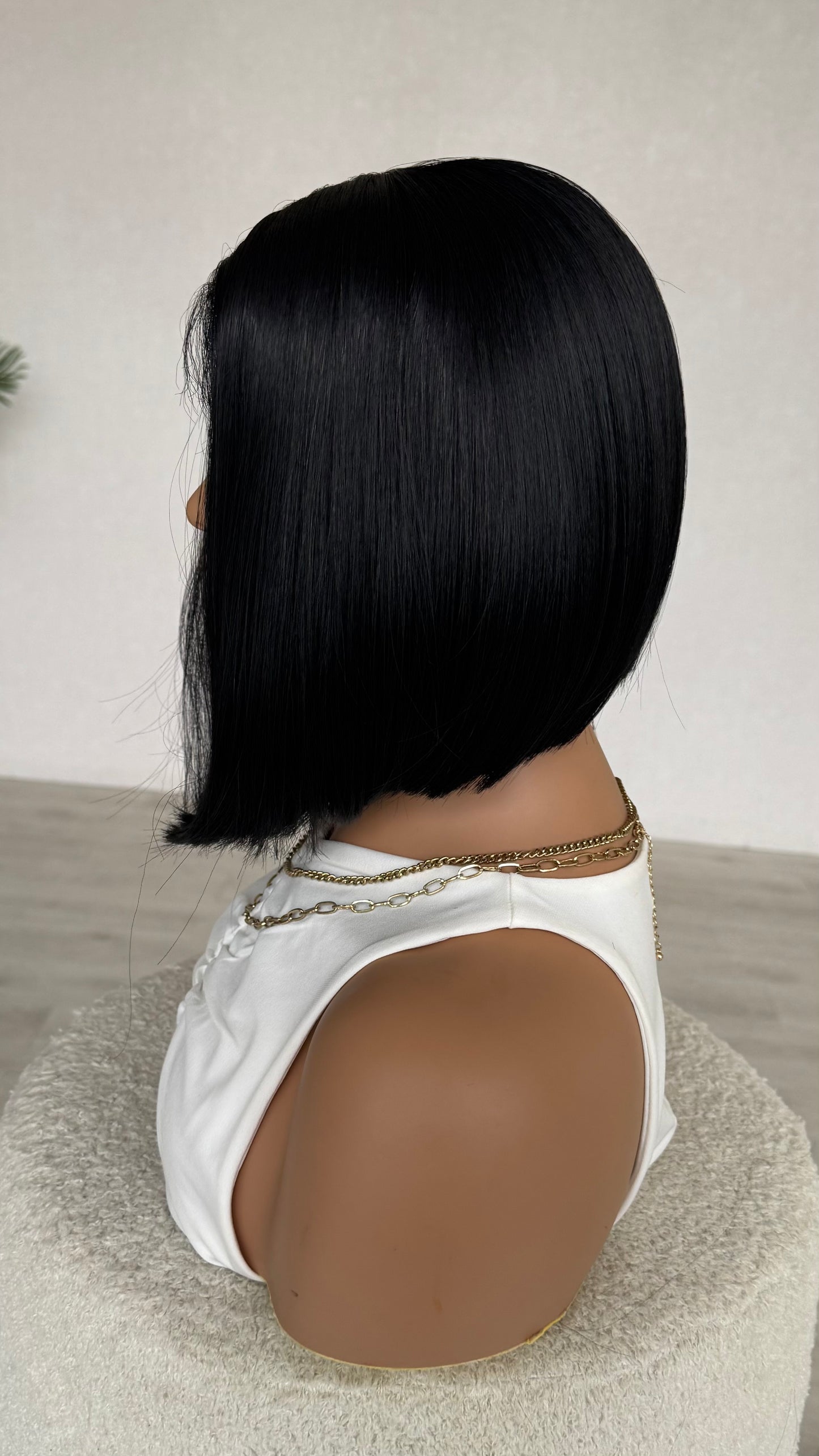 side on view, black concave bob. 12 inch length. silky black hair, heat safe.