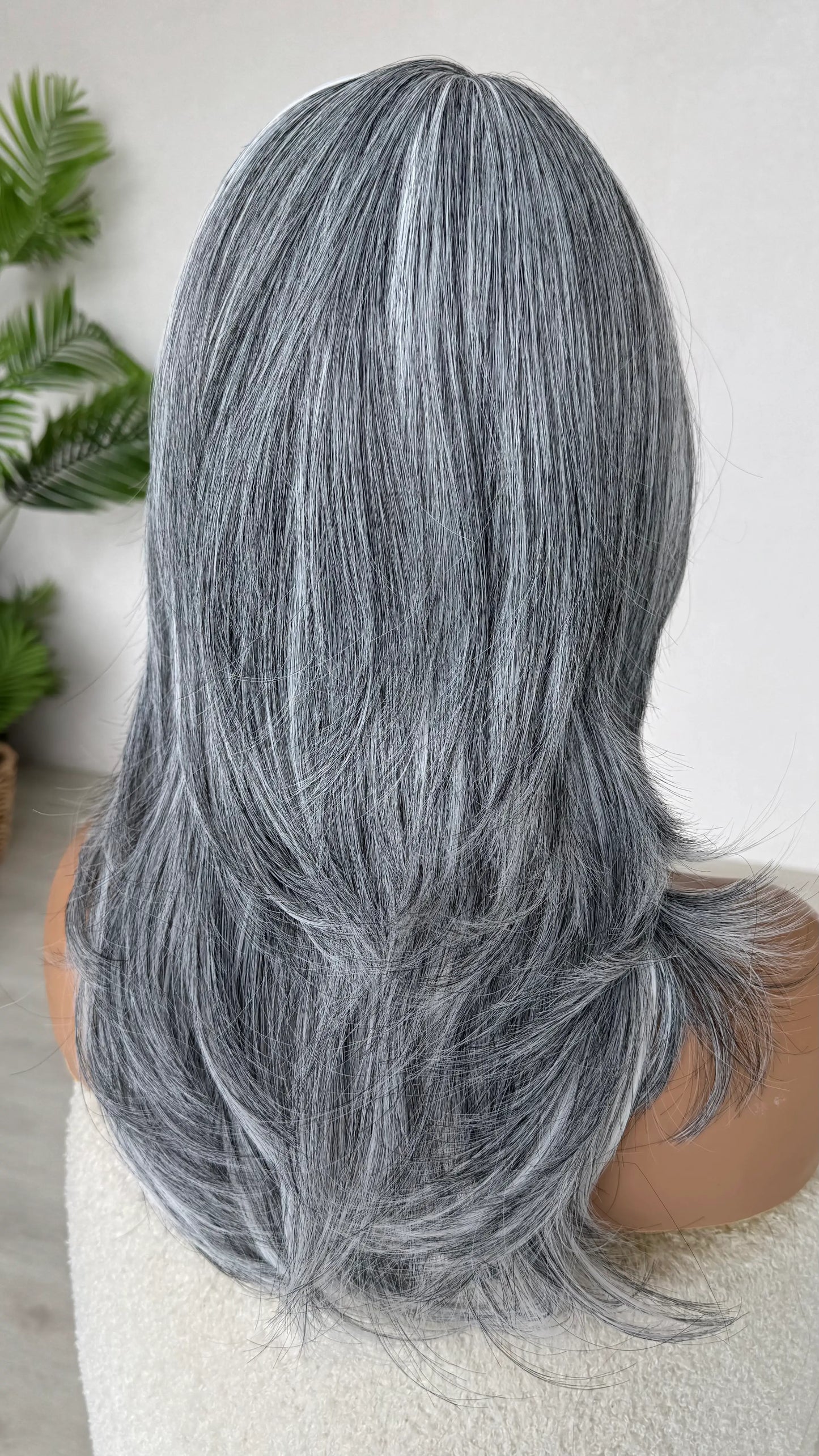 grey view back view, salt and pepper coloured hair with layers and curtain bangs