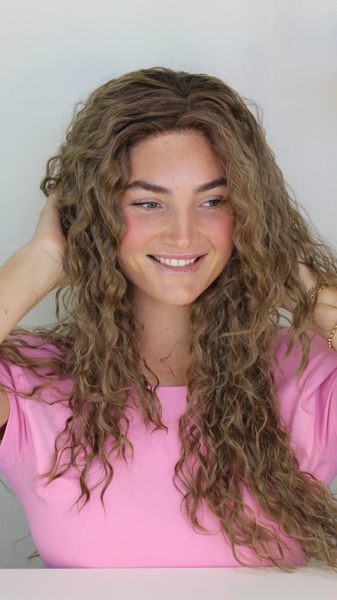Close-up of a premium synthetic wig styled with soft waves, looking effortlessly natural.