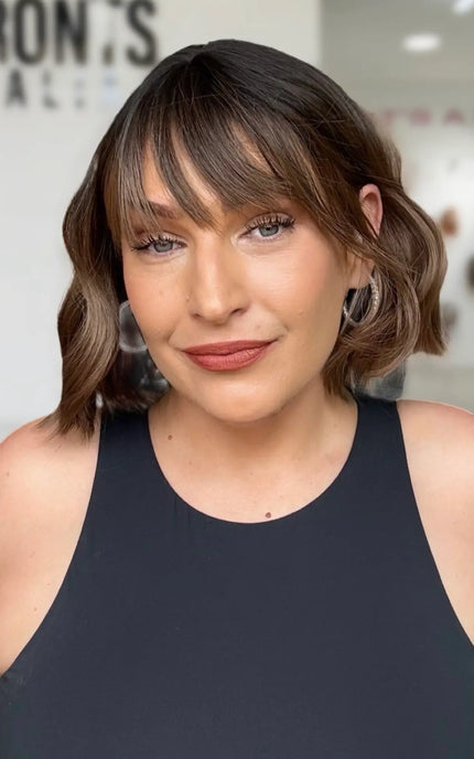 a 10 inch wavy hair short bob with a long fringe and wavy brunette hair with lighter warm brunette ends. Dark roots with middle part.