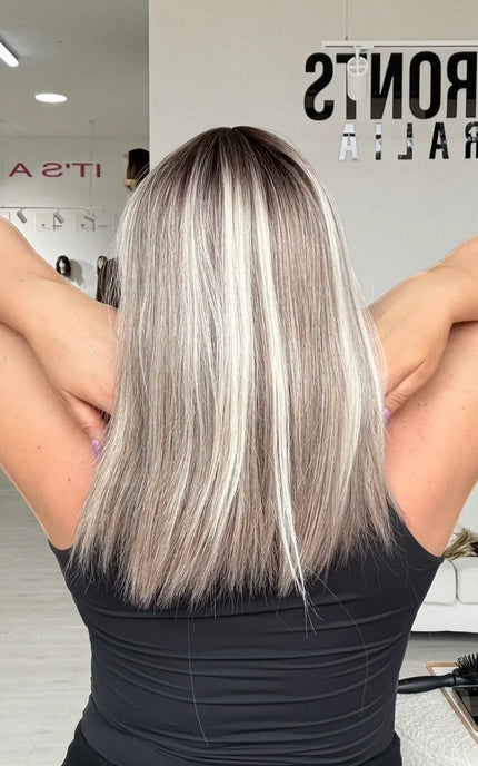 back view of straight cut across ash grey highlighted hair, straight hair with darker root and light highlights. 