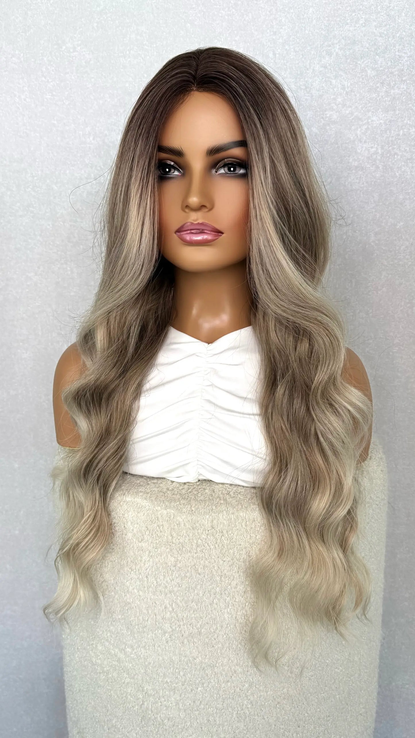 ash blonde wig from the side. showing the ombre ash colour with face framing highlights. heat friendly synthetic wig.