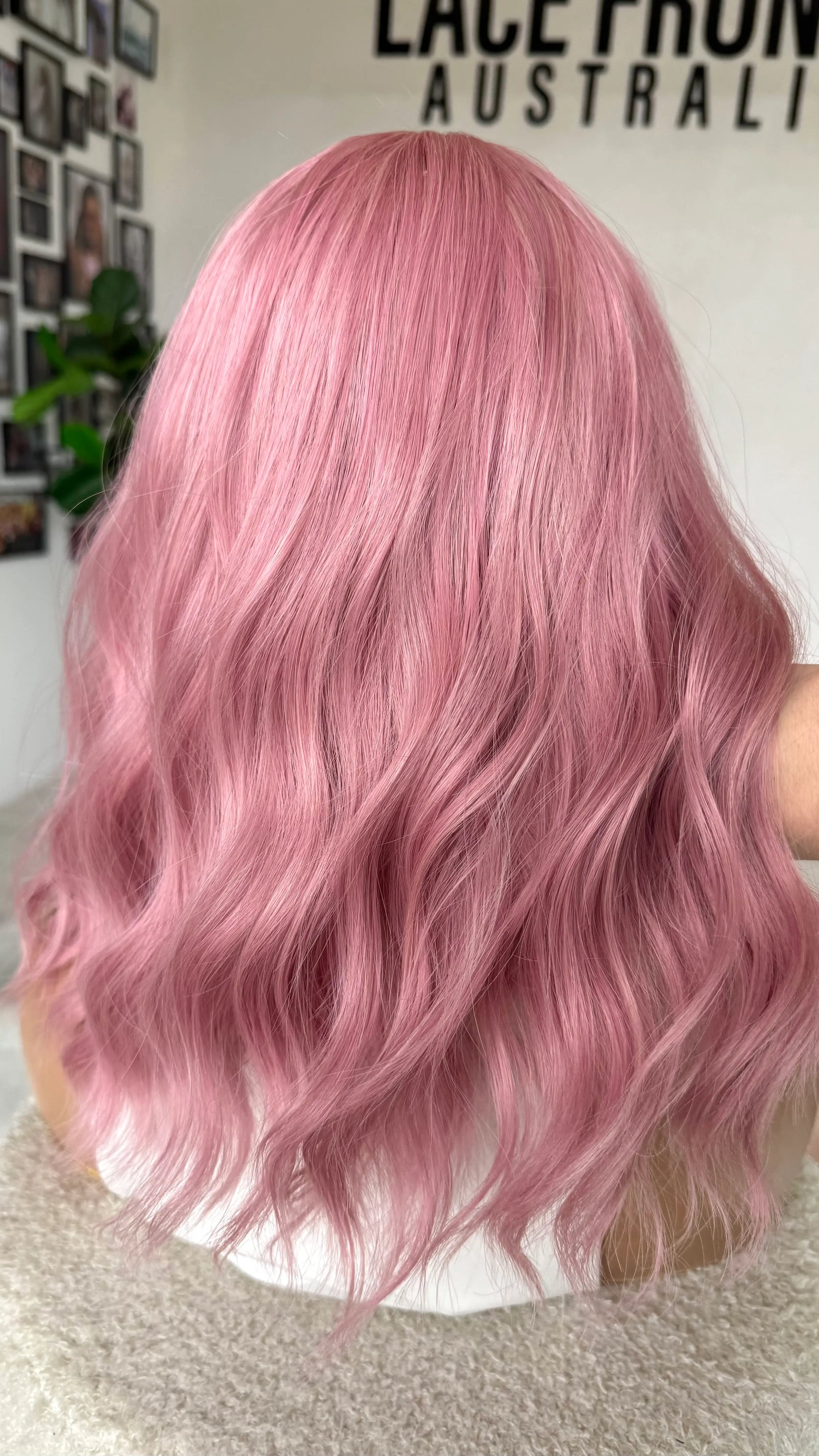 Wavy pink hair from the back view, holding up the wavy hair, heat safe.