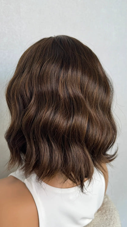Dak Brunette synthetic wig from the back wavy with a fringe. 