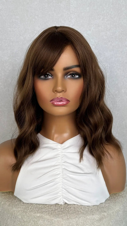 A chocolate brown synthetic wig with a fringe. 14 inches, wavy. fringe styled to the side. 