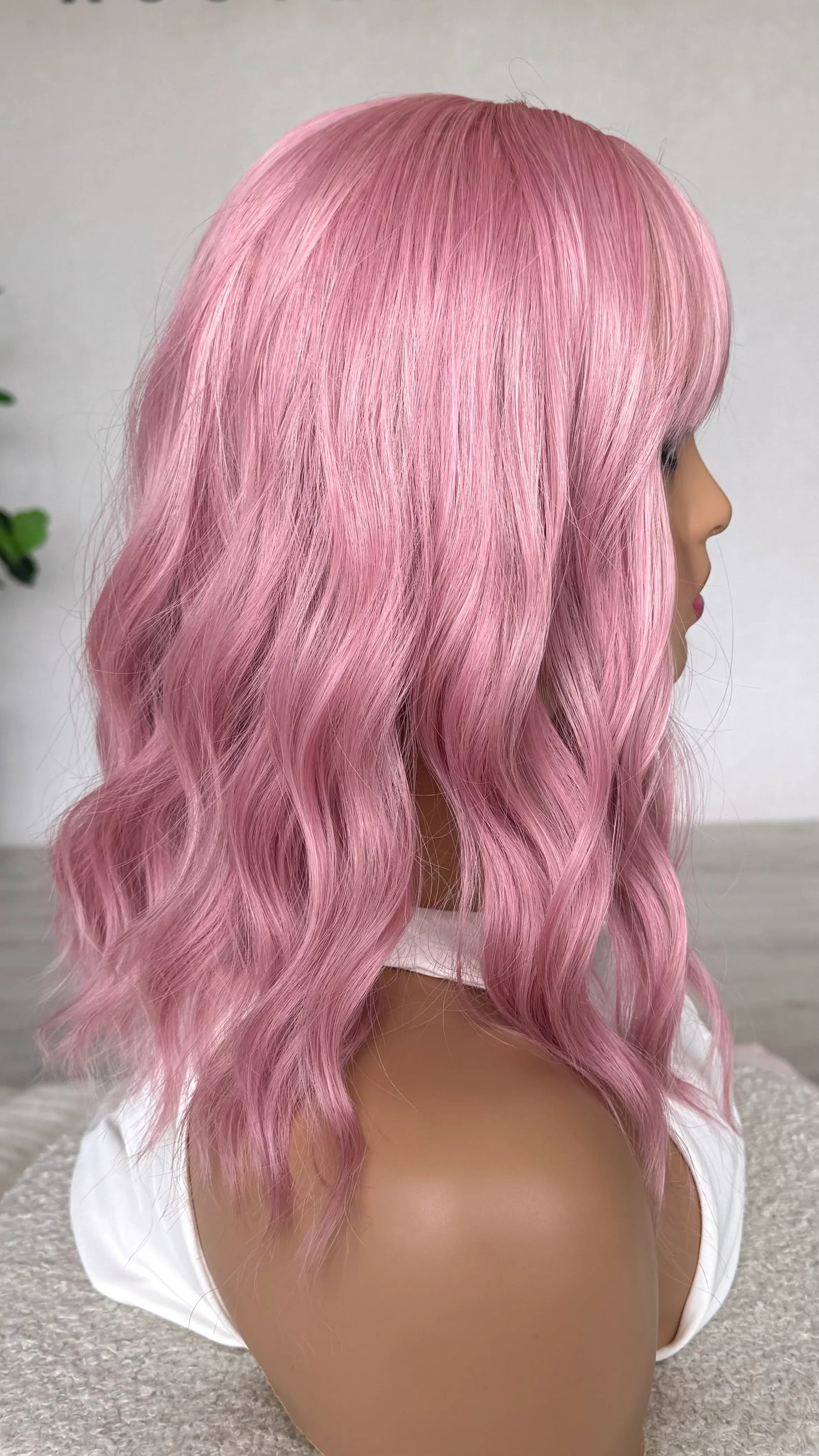 pink wavy bob wig from the side. pearl pink hair, heat safe hair.