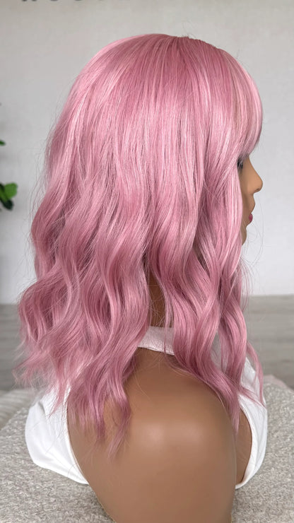 pink wavy bob wig from the side. pearl pink hair, heat safe hair.