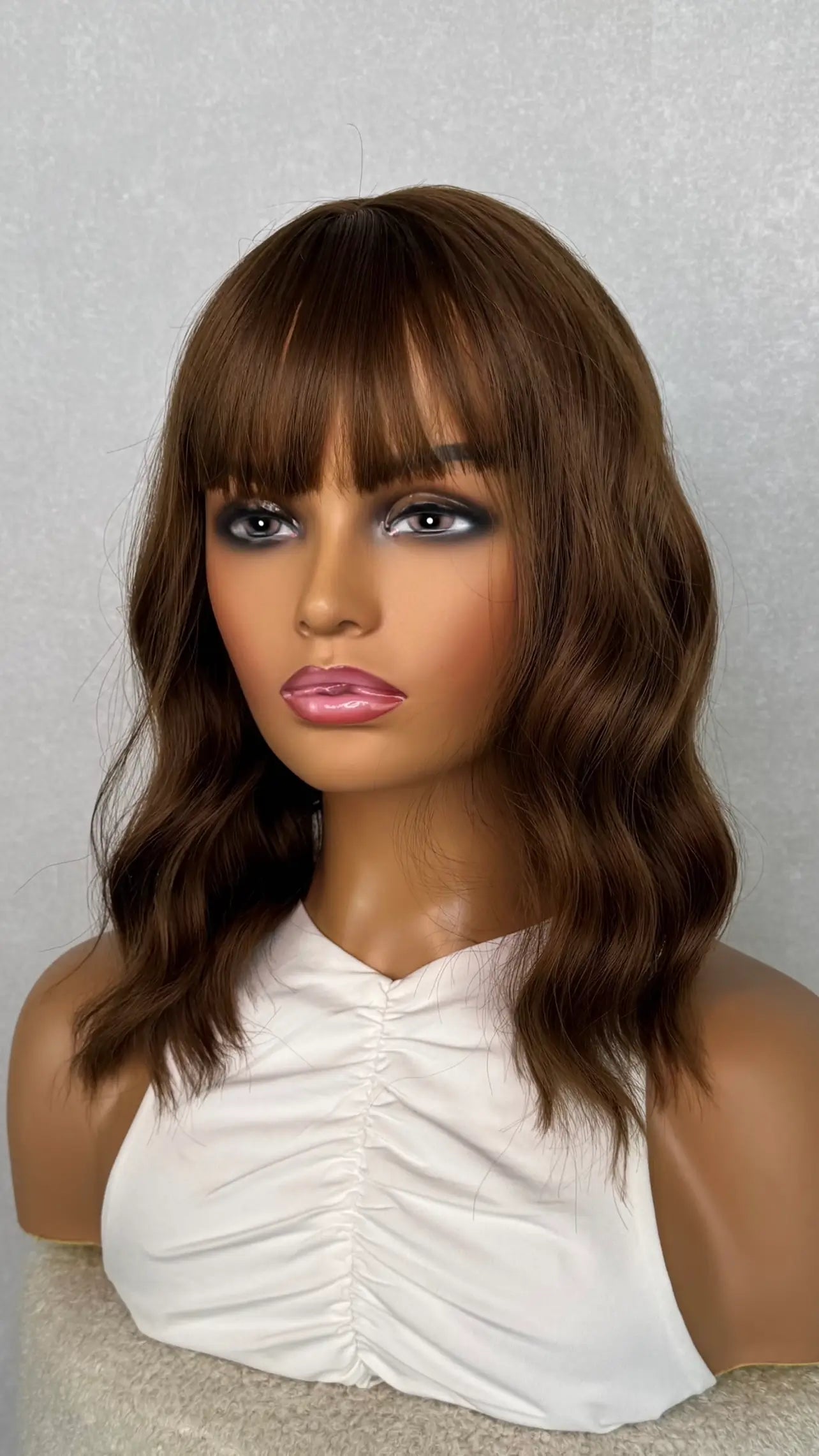 a brunette wig with a fringe, 14 inches. wavy. fringe styled forward.