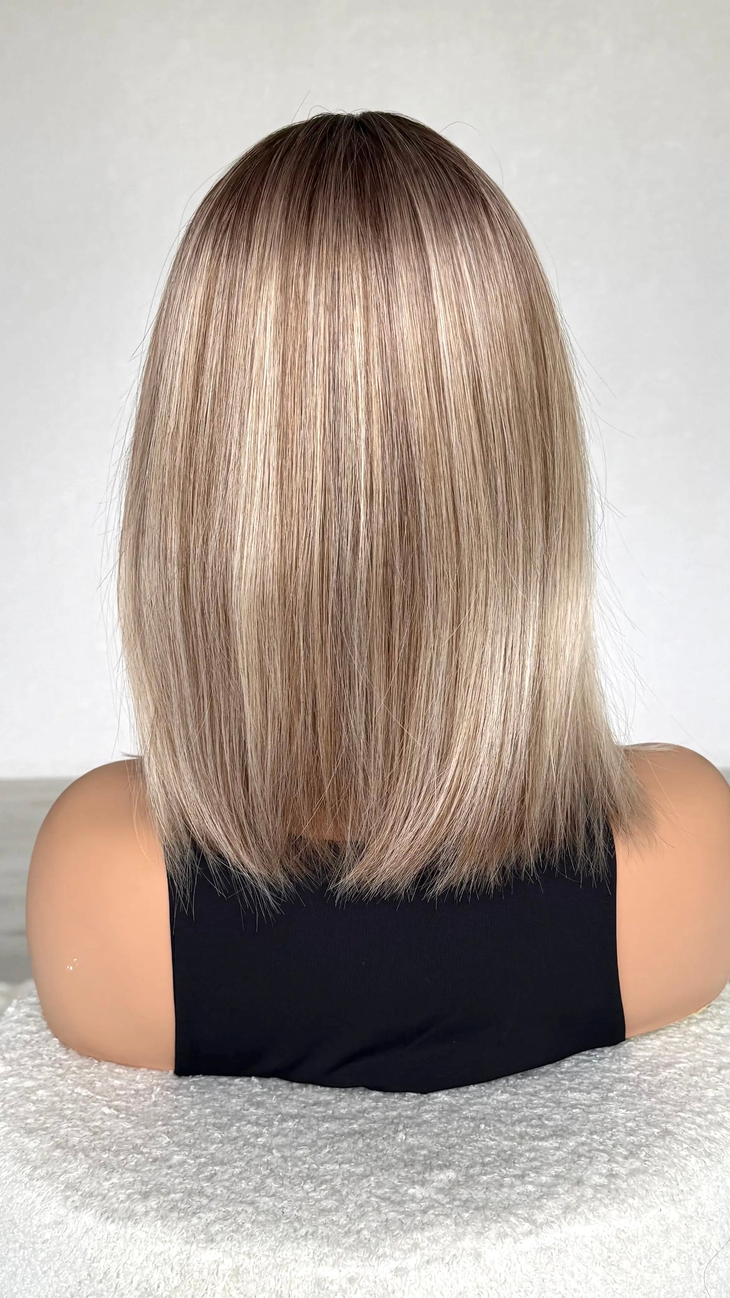Back view of shimery hair, ombre blonde hair with fringe.