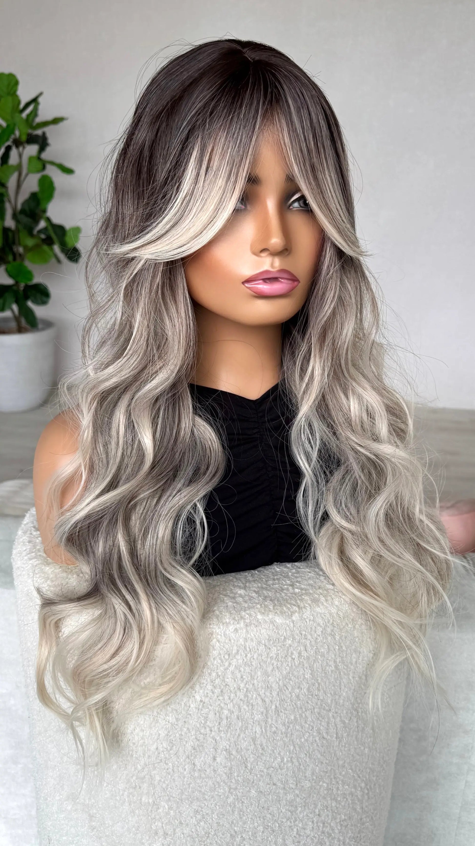 side view showing curtain bangs and dark root to light blonde.