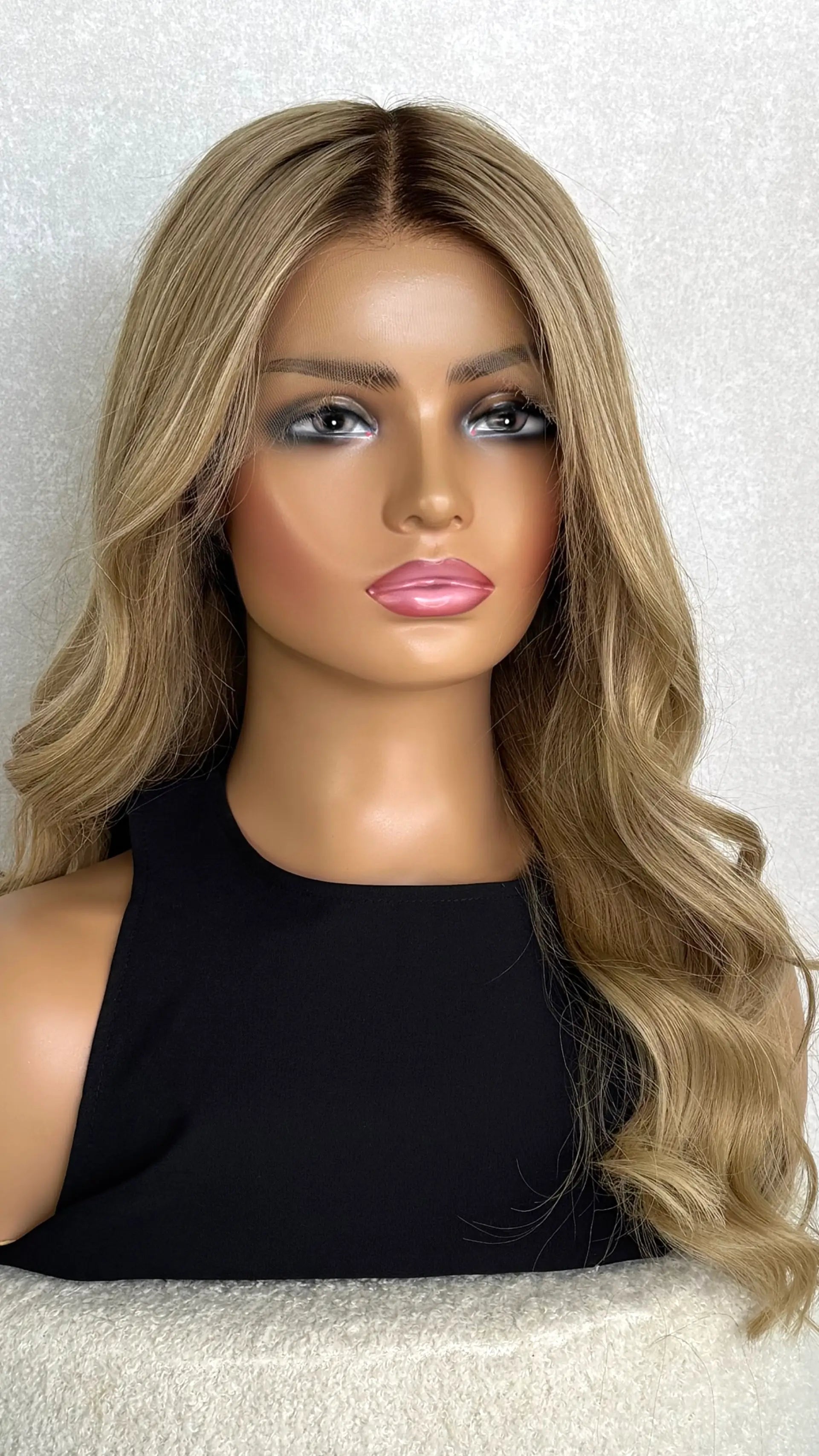 A 22-inch human hair lace front wig in golden blonde with subtle highlights, styled in soft waves