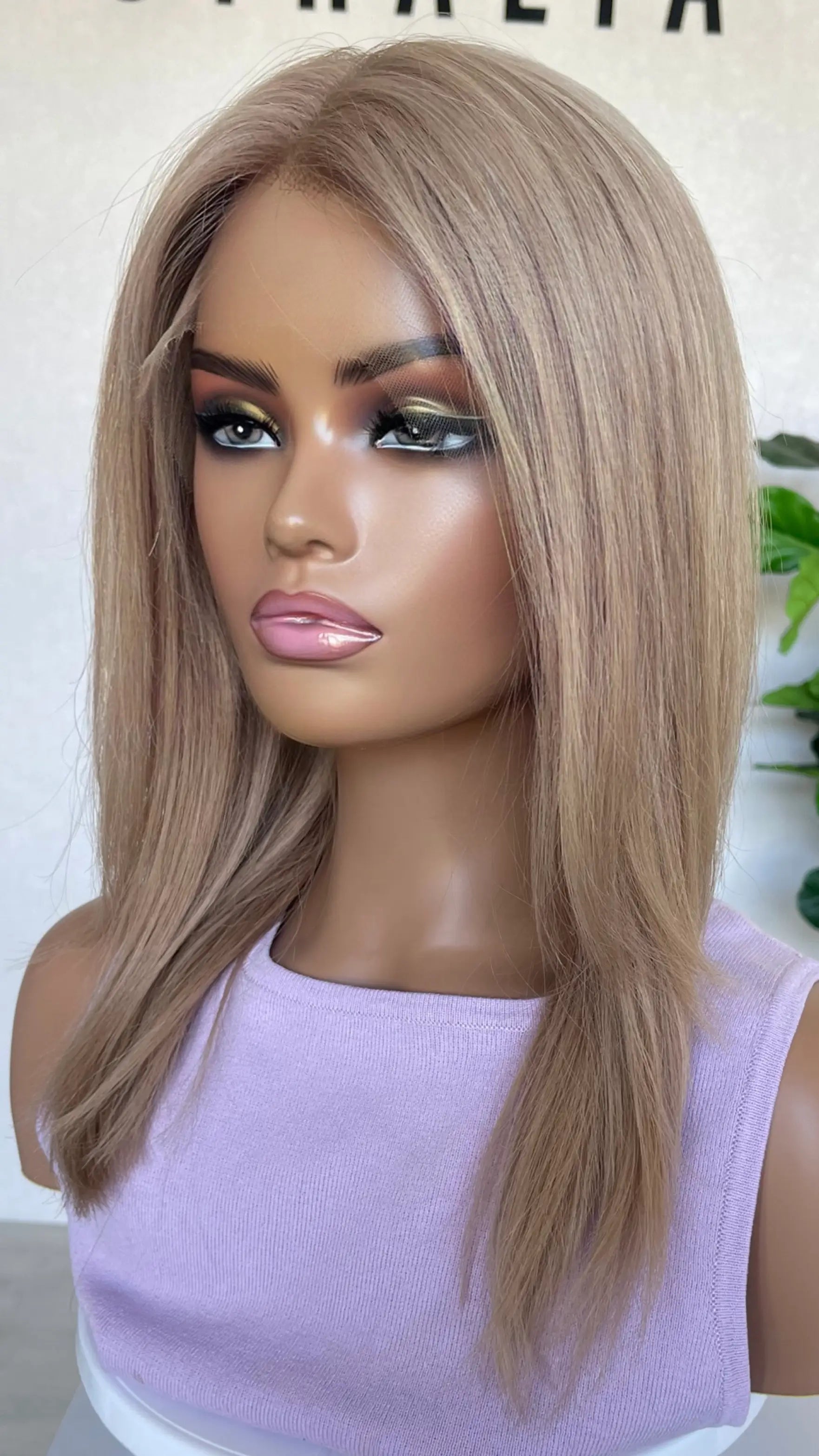 side profile of the Serena wig, highlighting its seamless lace front and silky texture in a warm rose gold blonde tone
