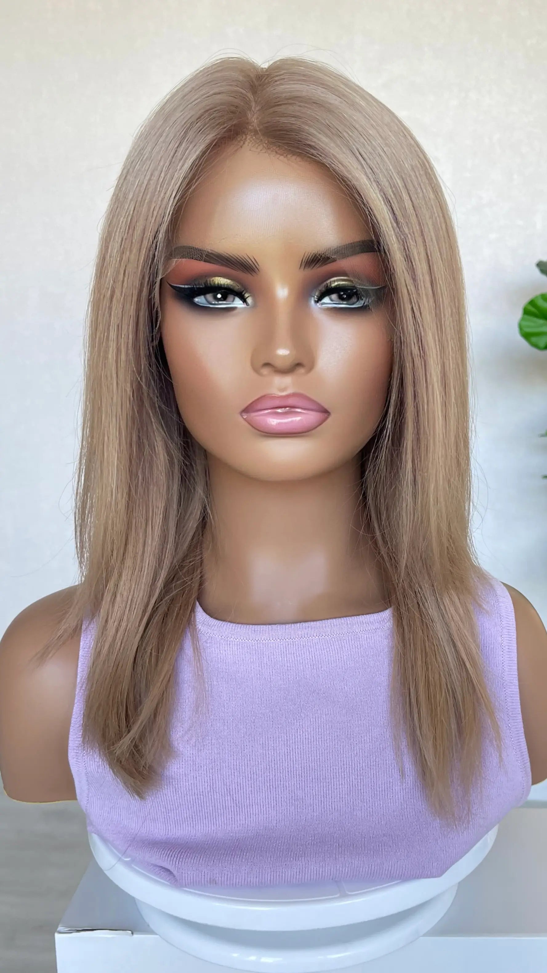 A 16-inch human hair lace front wig in soft rose gold blonde, featuring a luminous blend of pink and golden hues for a radiant look.