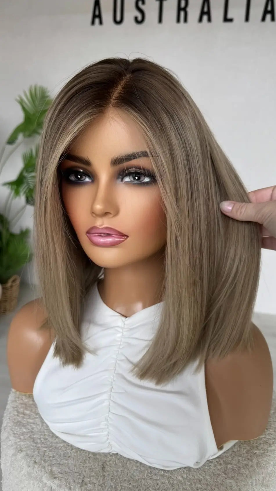 ash blonde wig with lowlights, holding the hair, money piece