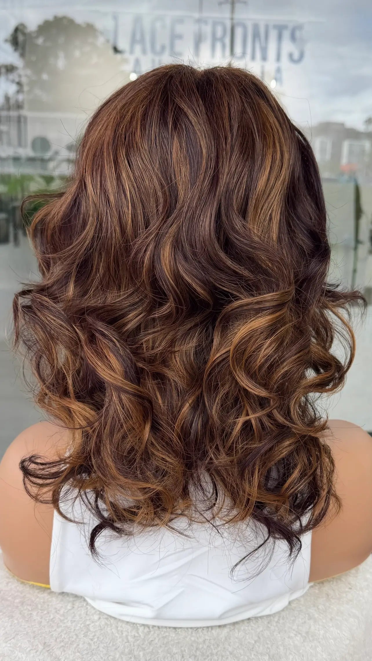 Curly wig with highlights from the back view. synthetic hair.