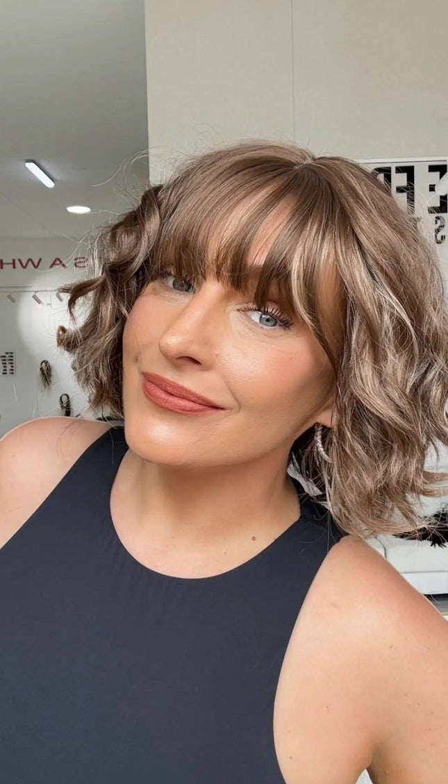 a wavy hair wig with soft fringe, light brown hair with highlights.