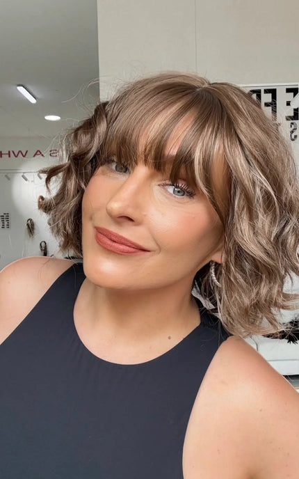 a wavy hair wig with soft fringe, light brown hair with highlights.