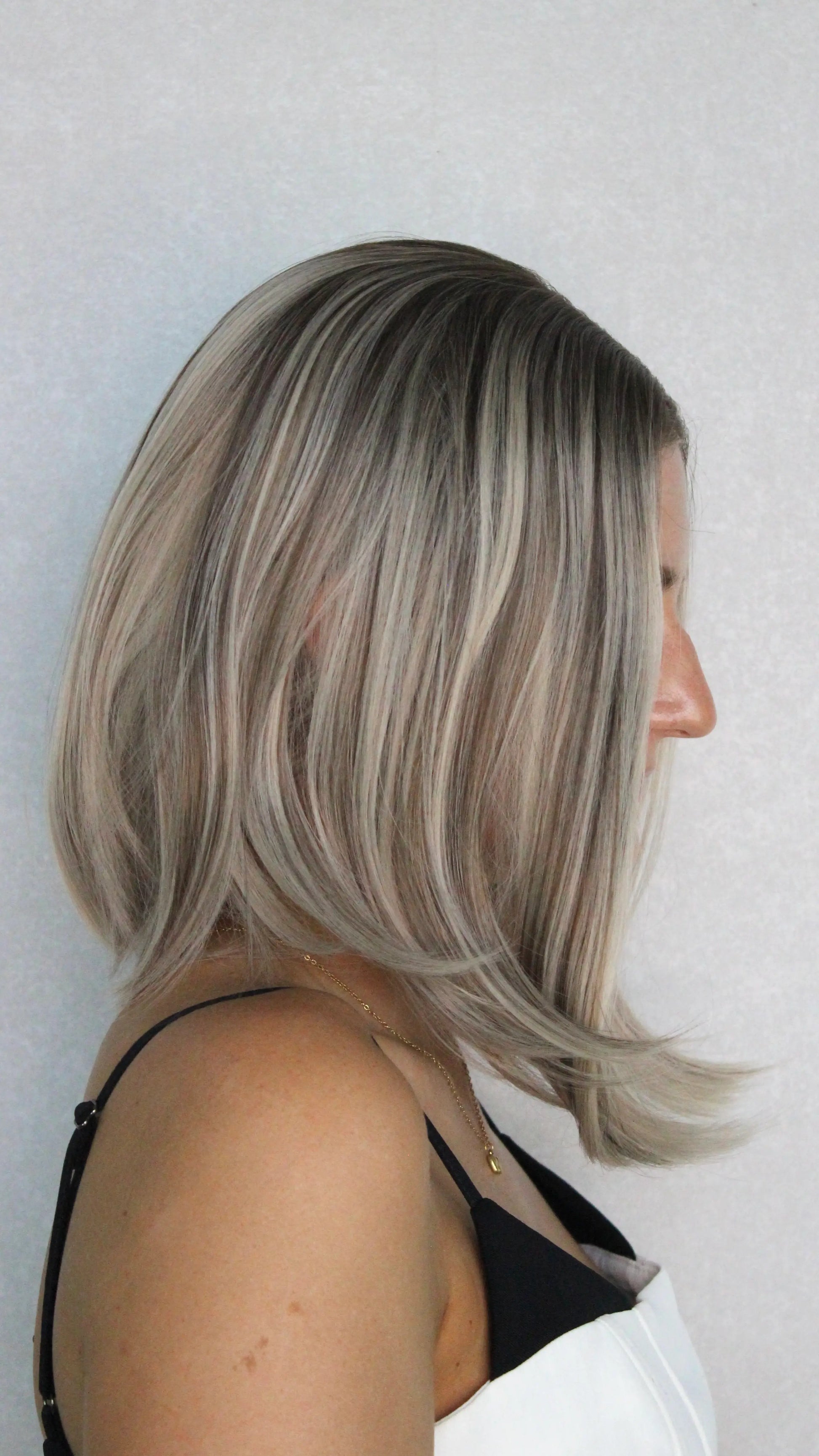 multi-toned blonde wig from the side, showing natural hairline, dark root. heat safe.
