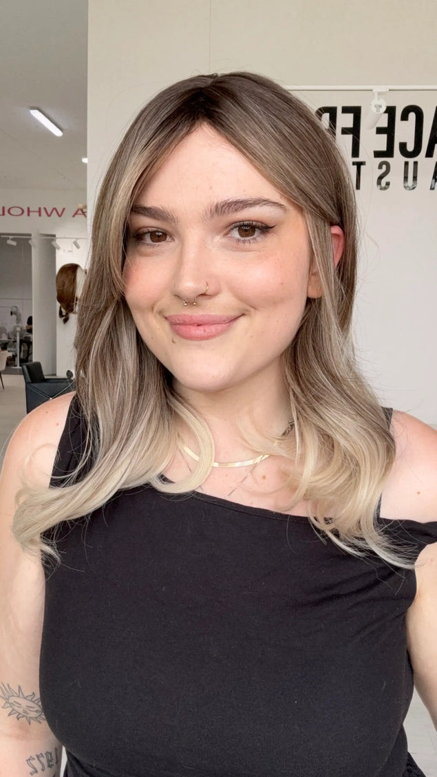 a short-mid length curled long bob with an ash ombre colour, from dark cool brunette roots to platinum blonde ends, this glueless wig is perfect for the lovers of ash blonde hair.