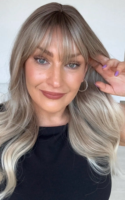 middle part with wispy fringe, ash blonde hair with platinum ends.