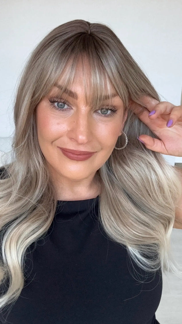 middle part with wispy fringe, ash blonde hair with platinum ends.