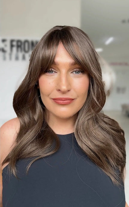 ash brunette layered hair with middle part and long curtain bangs. layers around the face for shaping.