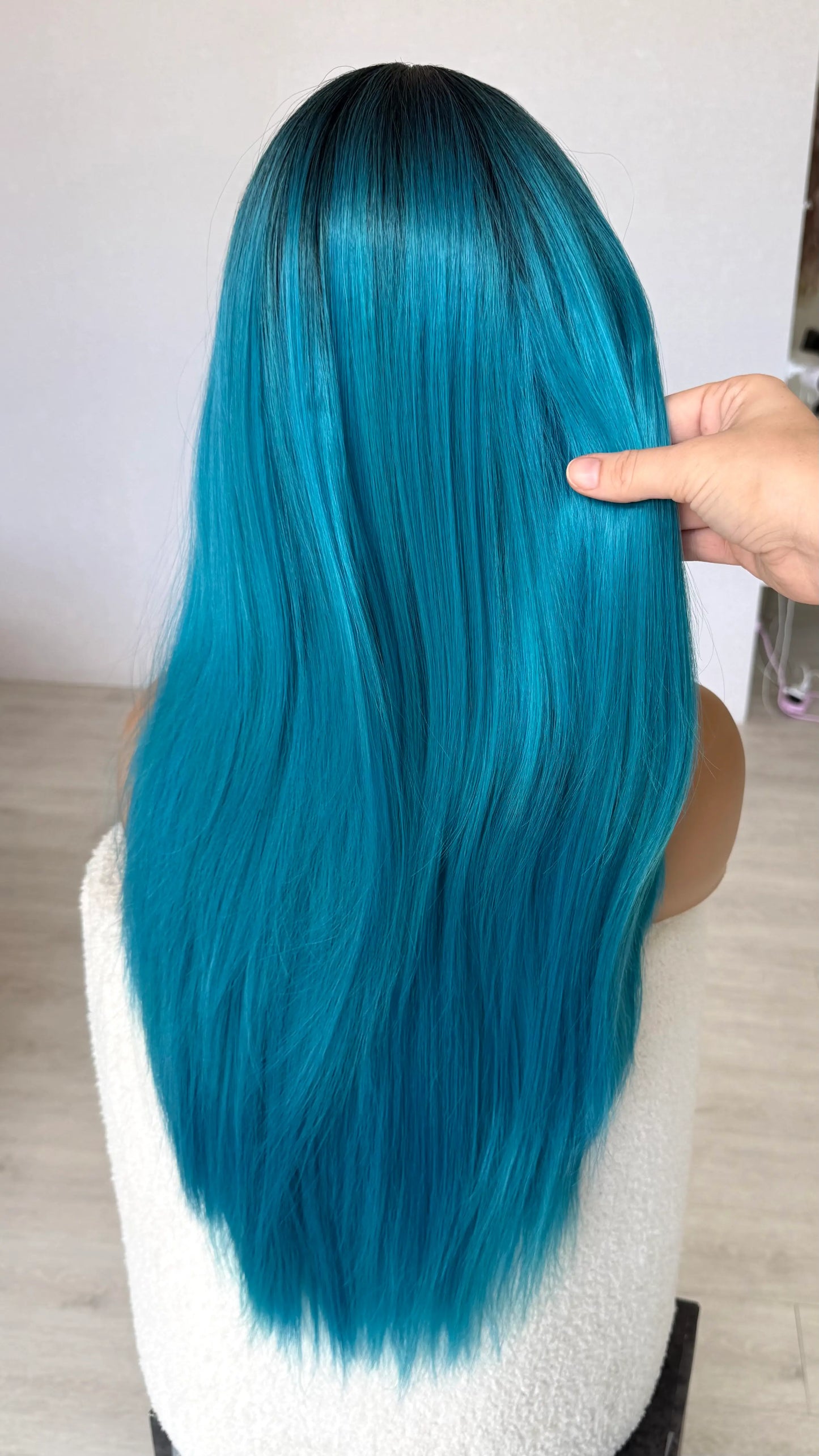 blue long hair synthetic wig, holding long hair from back view, straight hair, heat safe wig.