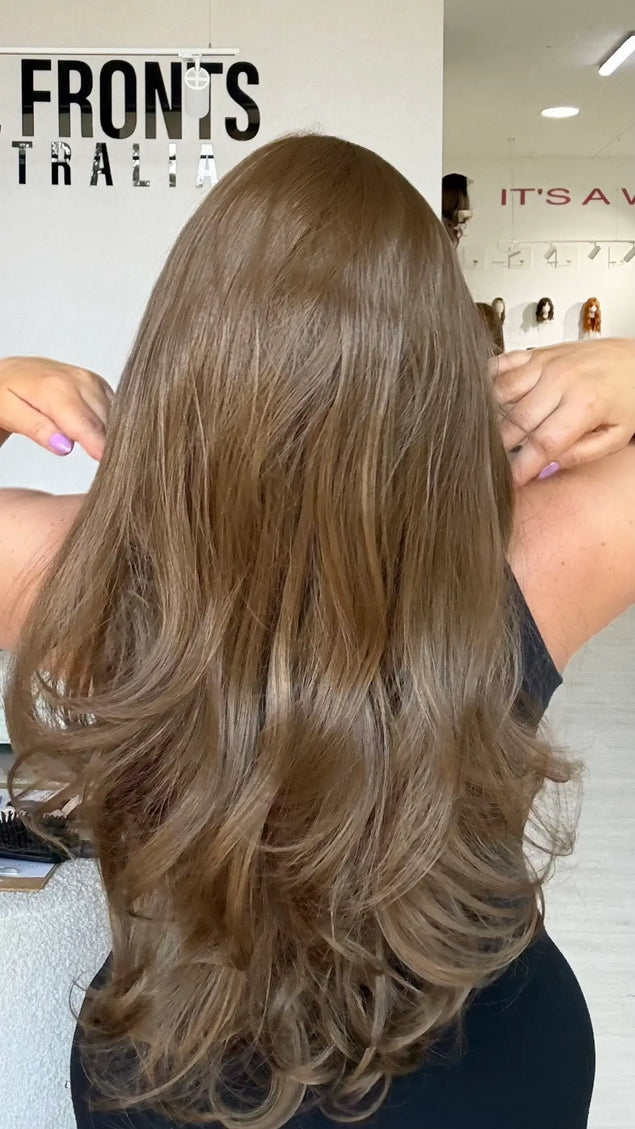 back view showing soft light brown hair with bouncy layers throughout and flicky ends.