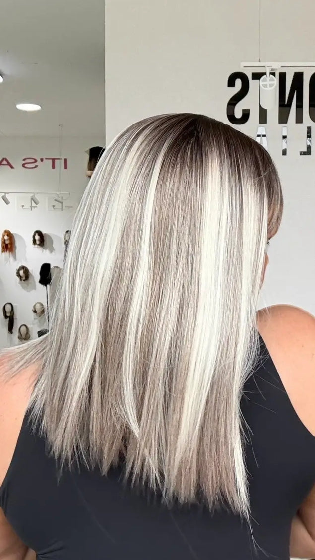 close up shot of highlighted light blonde platinum highlights and darker shadow root, ash grey mid tone, straight hair.