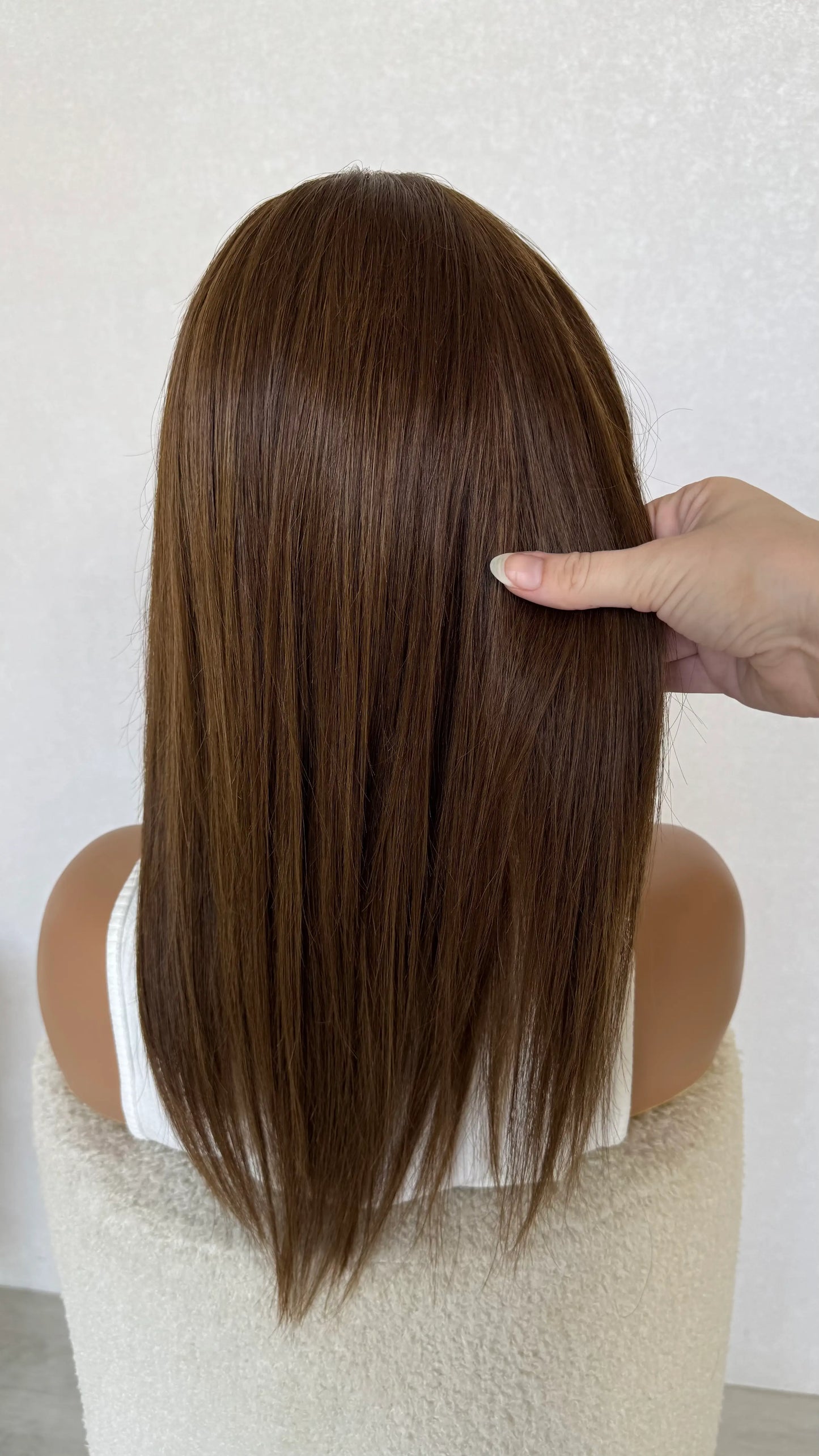 back view holding 18 inch golden brunette hair 