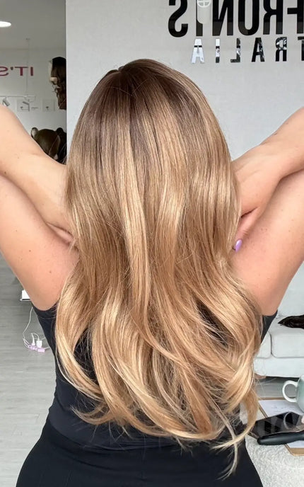 a golden brunette to blonde ombre with light layers and a very soft curl. a slight root shadow with a glueless cap for easy wear.